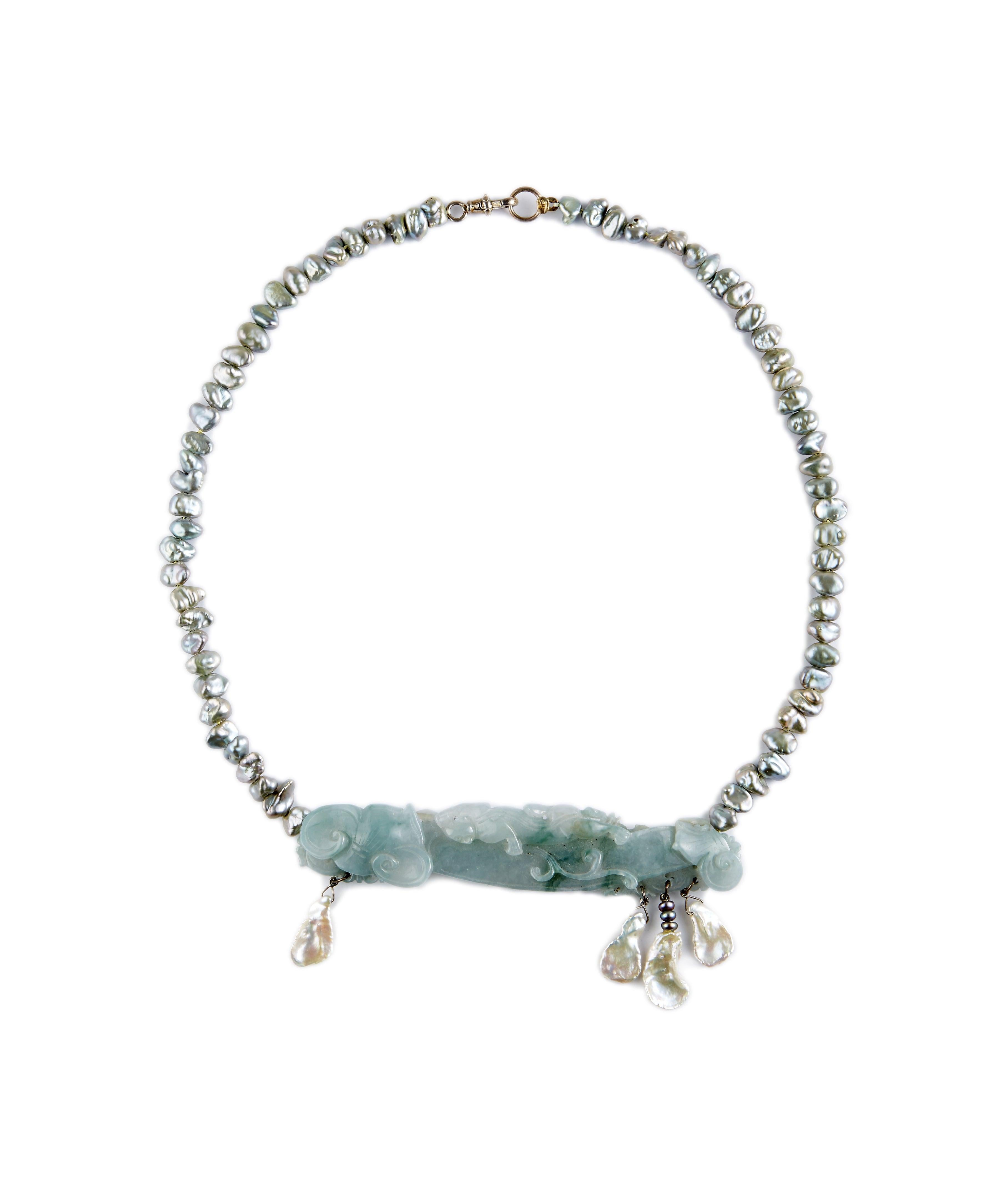 Erin Mac Blue Jade is the most unusual color Jadeite. This one is soft and awaits your meditation, bringing peace to your day... Hand-carved and dangles of white freshwater pearls draping from a strand of delicious blue/grey freshwater pearls. I was
