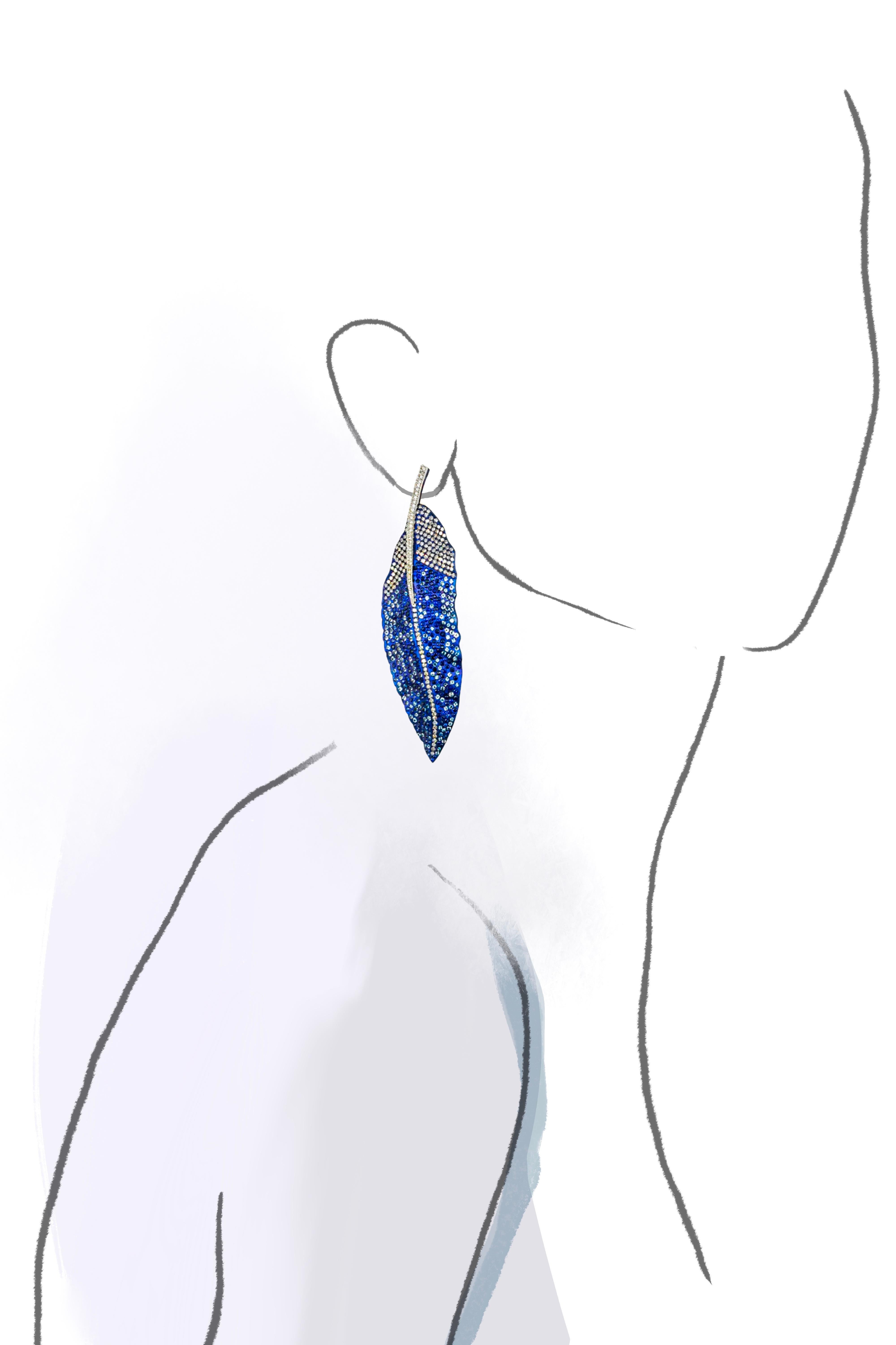 Adorn yourself with the beauty of nature with our handcrafted Blue Jay feather earrings. Set with an impressive 1248 gems, including 482 diamonds weighing 4.66 carats, 438 blue sapphires weighing 6.92 carats and 328 aquamarines weighing 3.66 carats.
