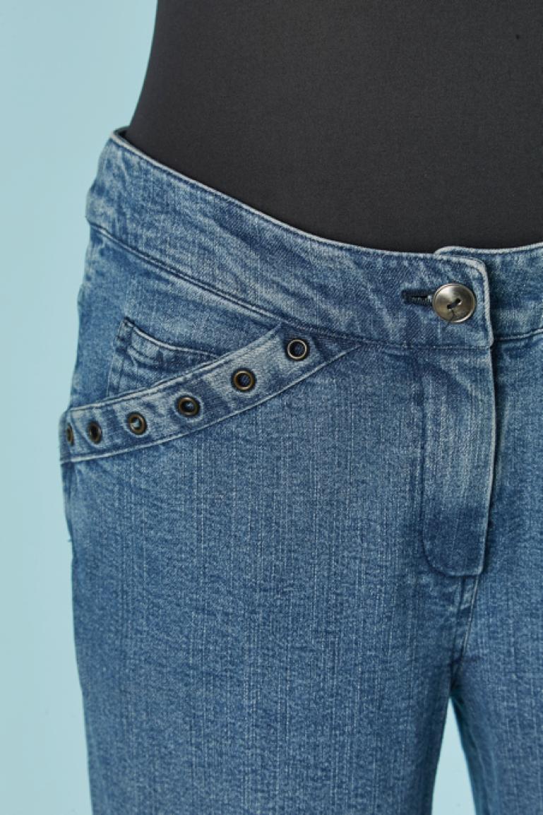 Blue jeans with branded silver metal buckle on the bottom. Fabric composition: 98% cotton, 2% lycra. Eyelet on the front pocket edge. One back pocket. Rise: 22cm. Zip and branded button closure on the top middle front. 
SIZE 36 (Fr) 4 (Us) 