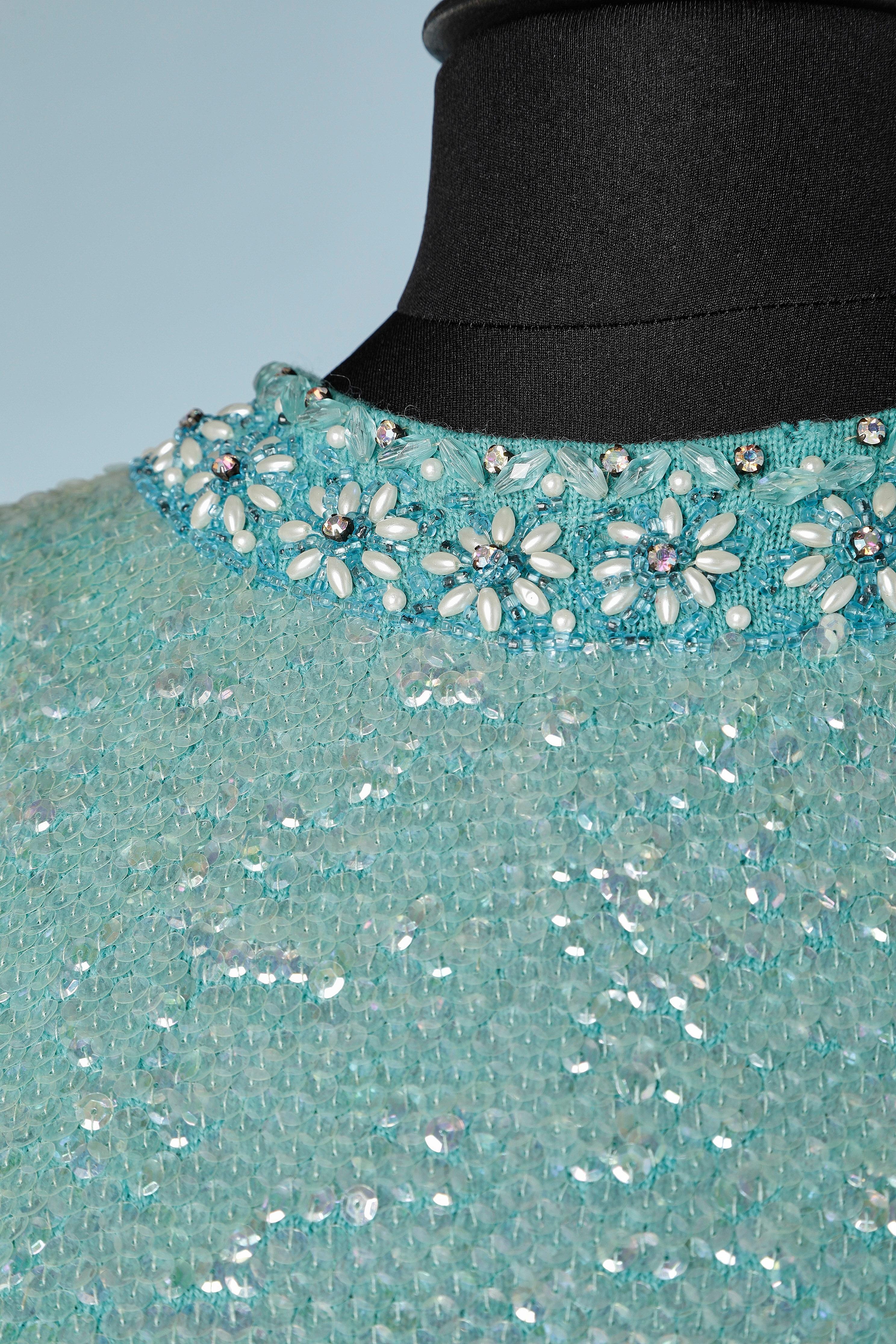 Blue wool knit sleeveless top covered with sequin, beads and rhinestone. Zip closure on the middle back. The lining is probably acetate or rayon.
SIZE M 