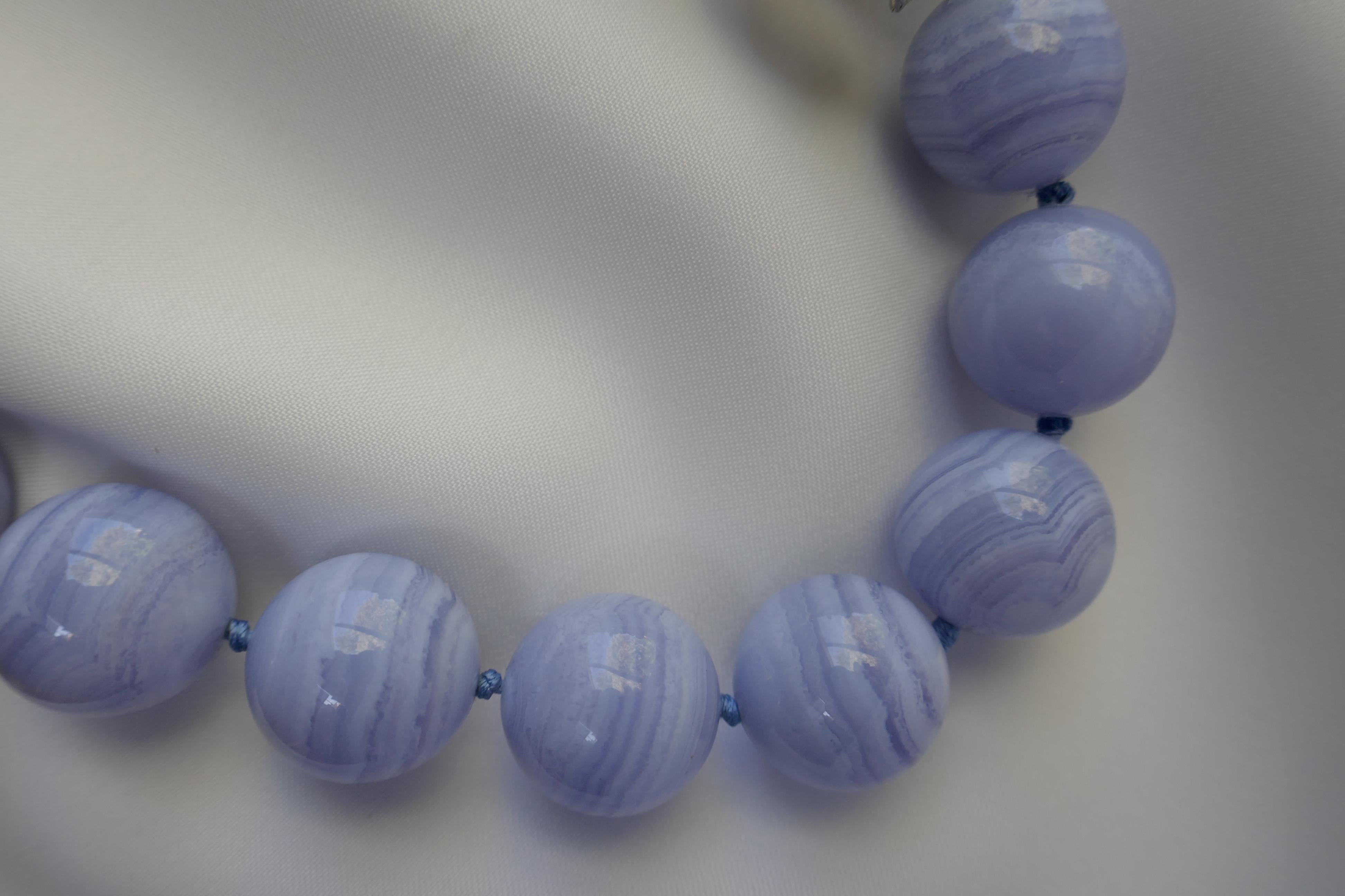 This necklace is 20mm blue lace agate. It is individually knotted on pale blue silk thread. It was 925 exclusive sterling silver pod clasp. The necklace was designed and created by Lucy de la Vega/de la Vega designs and made in the U.S. Only one