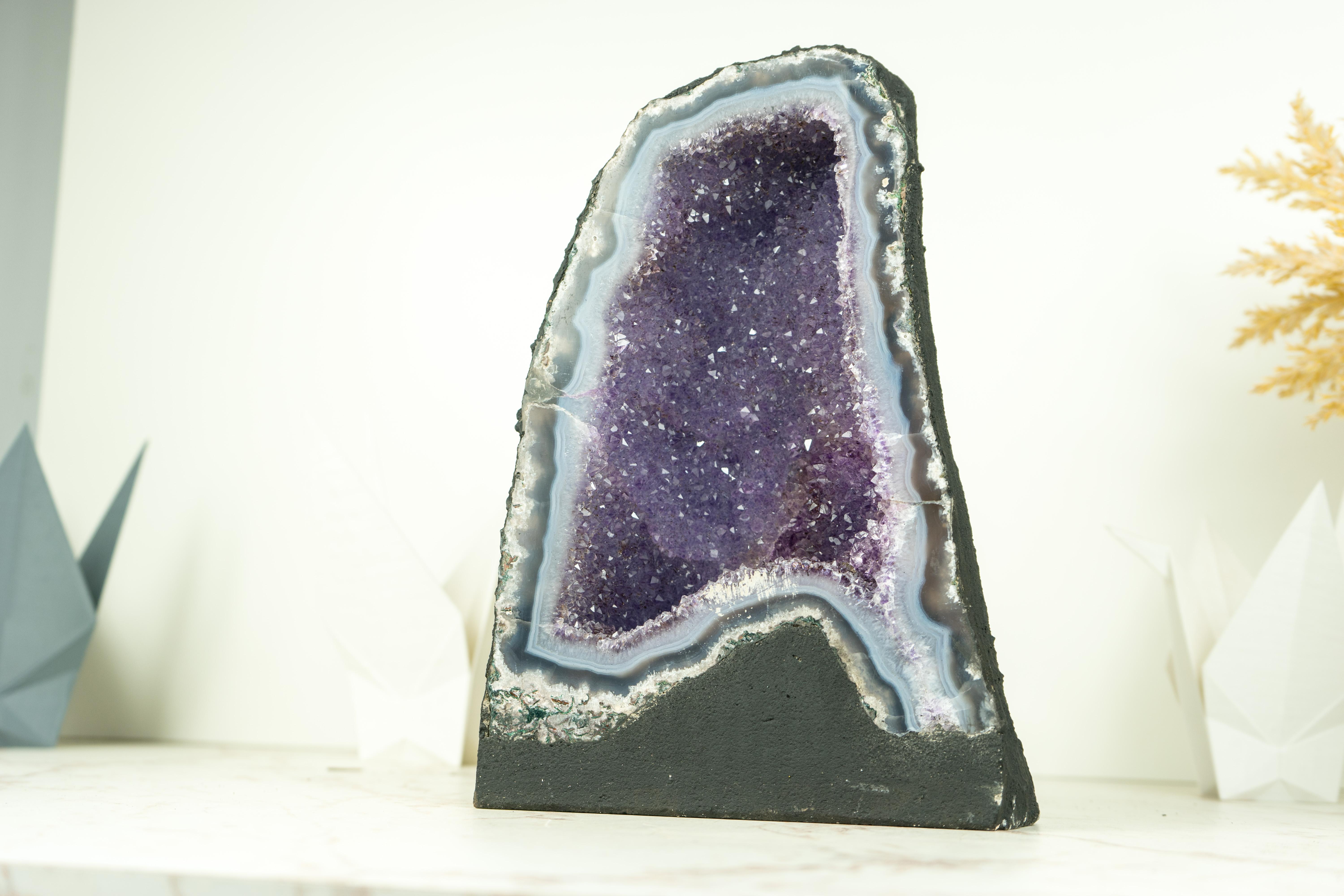Small in size, this natural Agate Geode brings many rare characteristics which turn it into a natural artwork. Those characteristics, as the blue agate band, the lavender galaxy druzy and the perfection of its natural drawings will shine at your