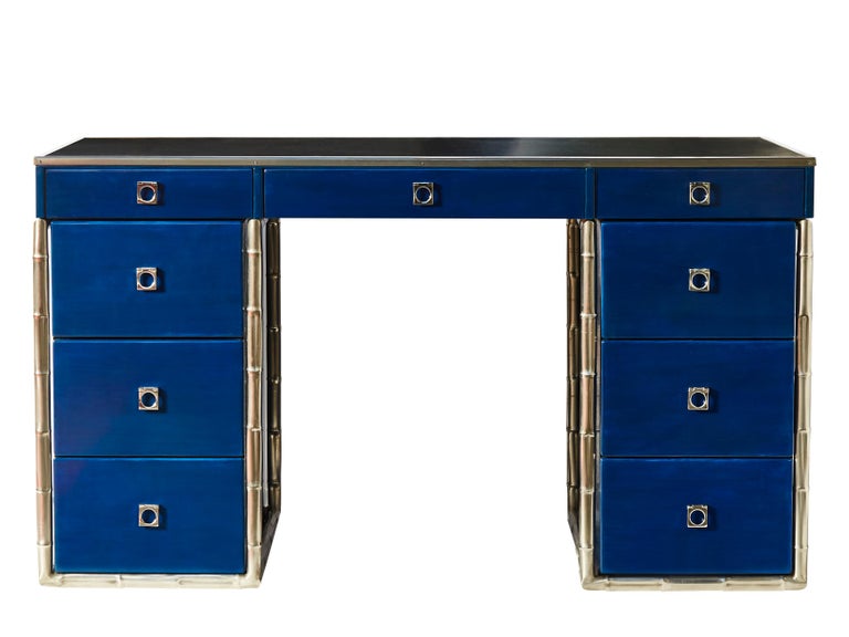 Beatiful desk designed by Guy Lefevre with decorative nickeled bamboo motifs feet. Nine drawers with Lefevre characteristic square handles and black leather top. The whole piece is covered in deep chic blue lacquer.