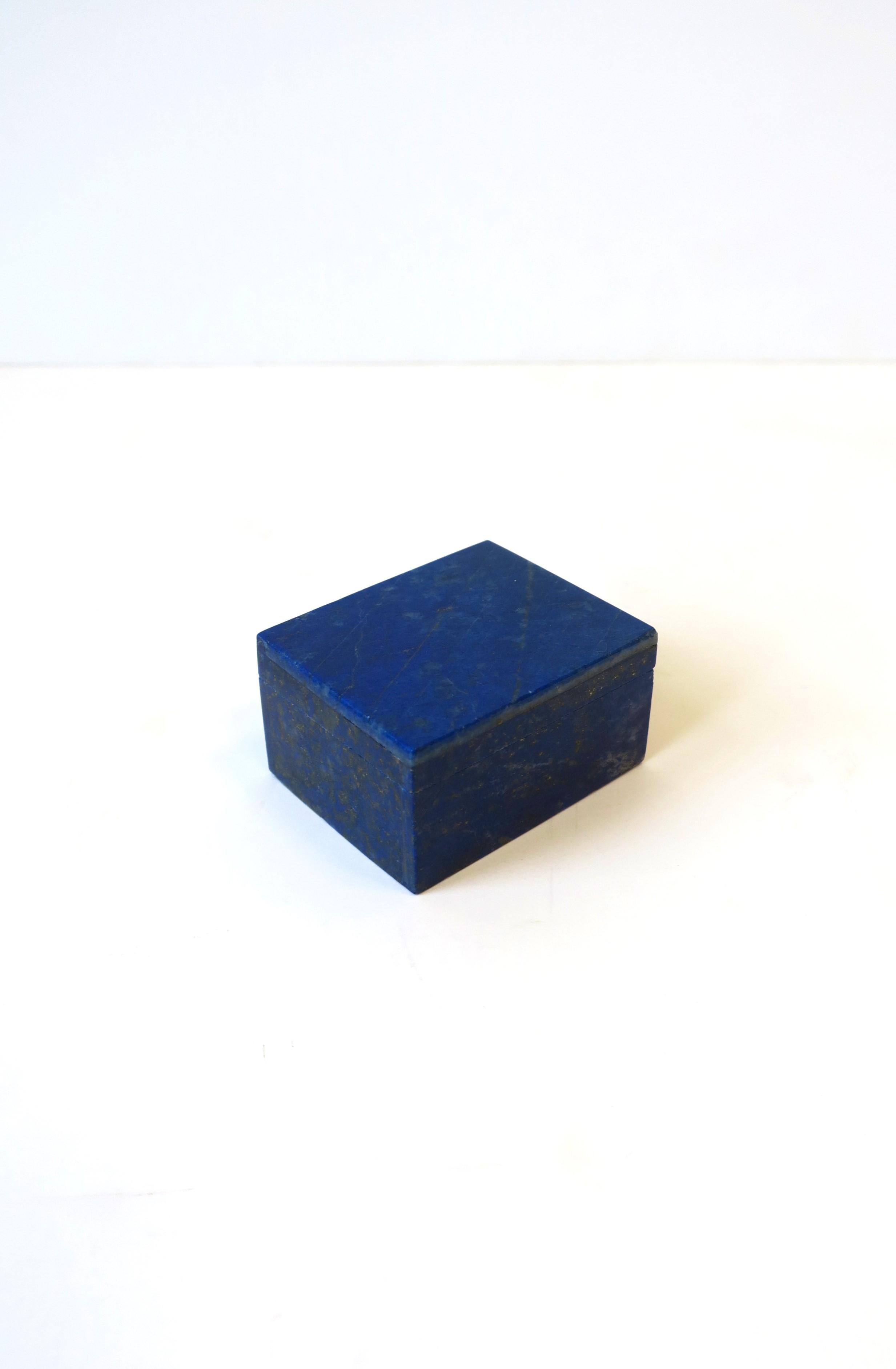 A small rectangular polished blue Lapis lazuli box, with matte white granite marble interior, which to hold jewelry (necklace/charm as shown) or other small items on a vanity, dresser, nightstand table, desk, etc. 

Dimensions: 1.44