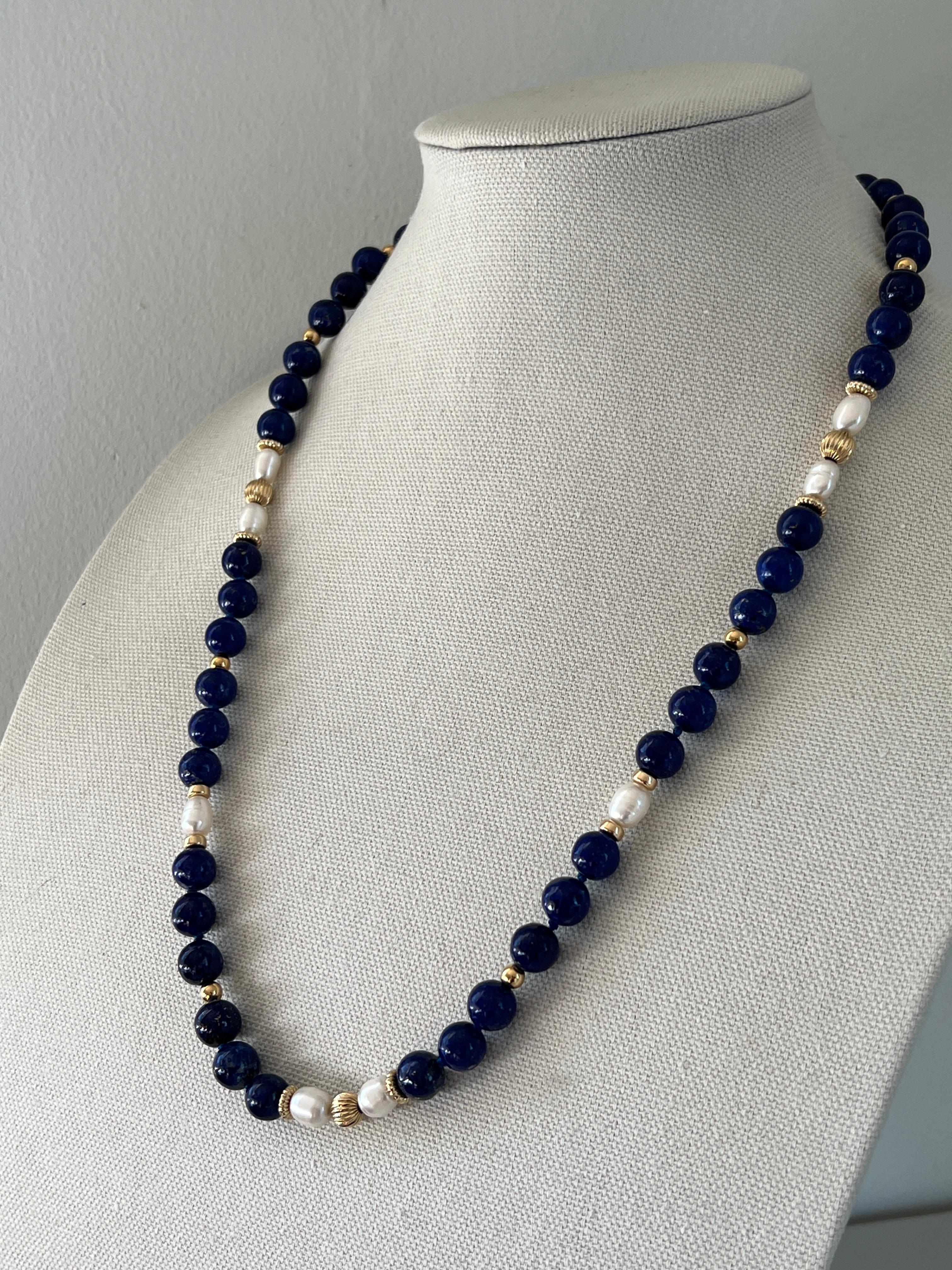 This exquisite 1980s necklace is crafted with 14-karat yellow gold beads, forty-eight round blue lapis lazuli beads and eight oval pearls.  The combination of the yellow gold, deep blue lapis and lustrous pearls creates a striking contrast that adds