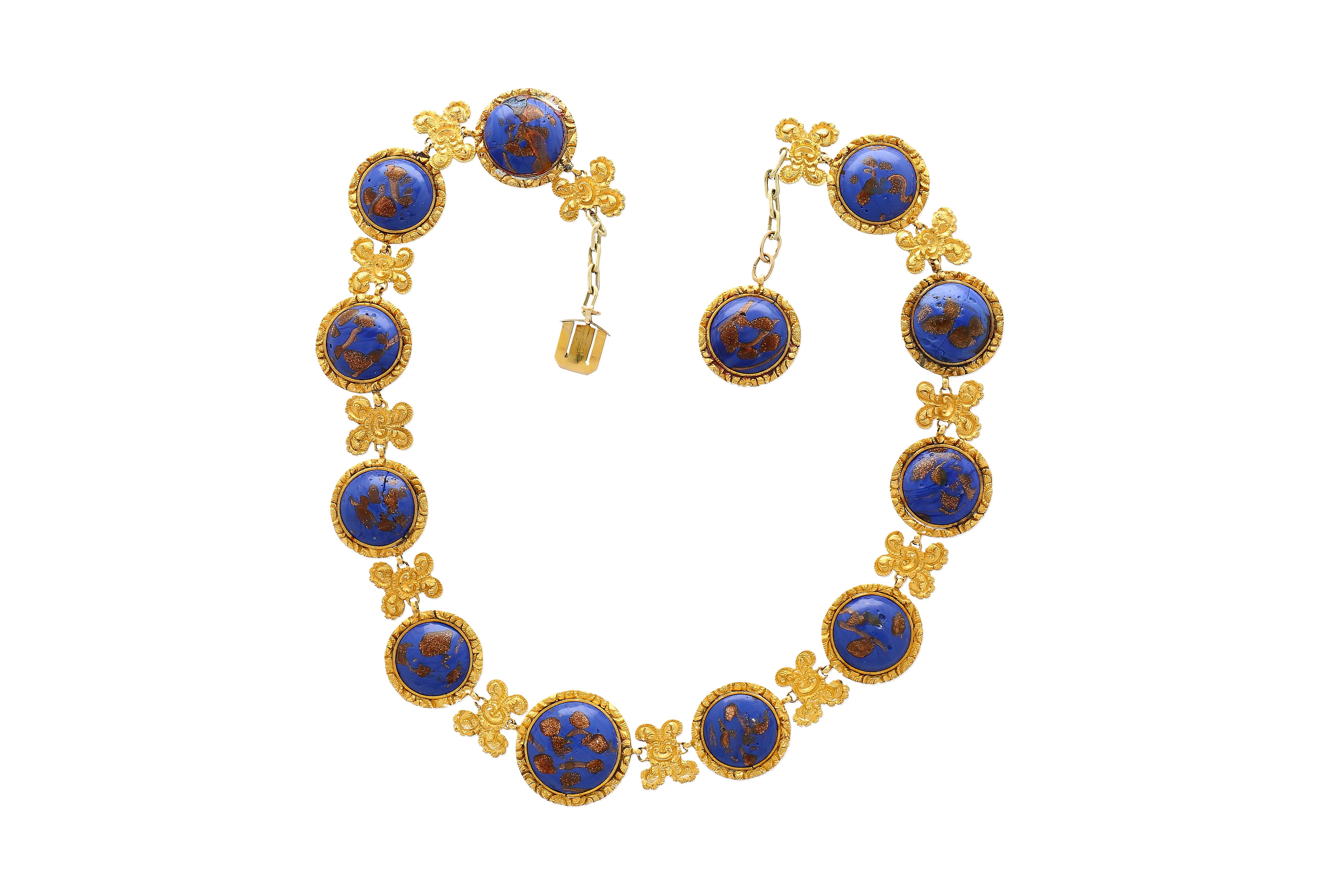 Lapis Necklace in 14k & 18K Gold. 

This Riviera styled necklace features 12 cabochon-cut lapis gemstones, each measuring 19–16 mm, and exhibits gold detailing within each stone, enhancing the royal blue hue. The necklace is crafted from 14K & 18K