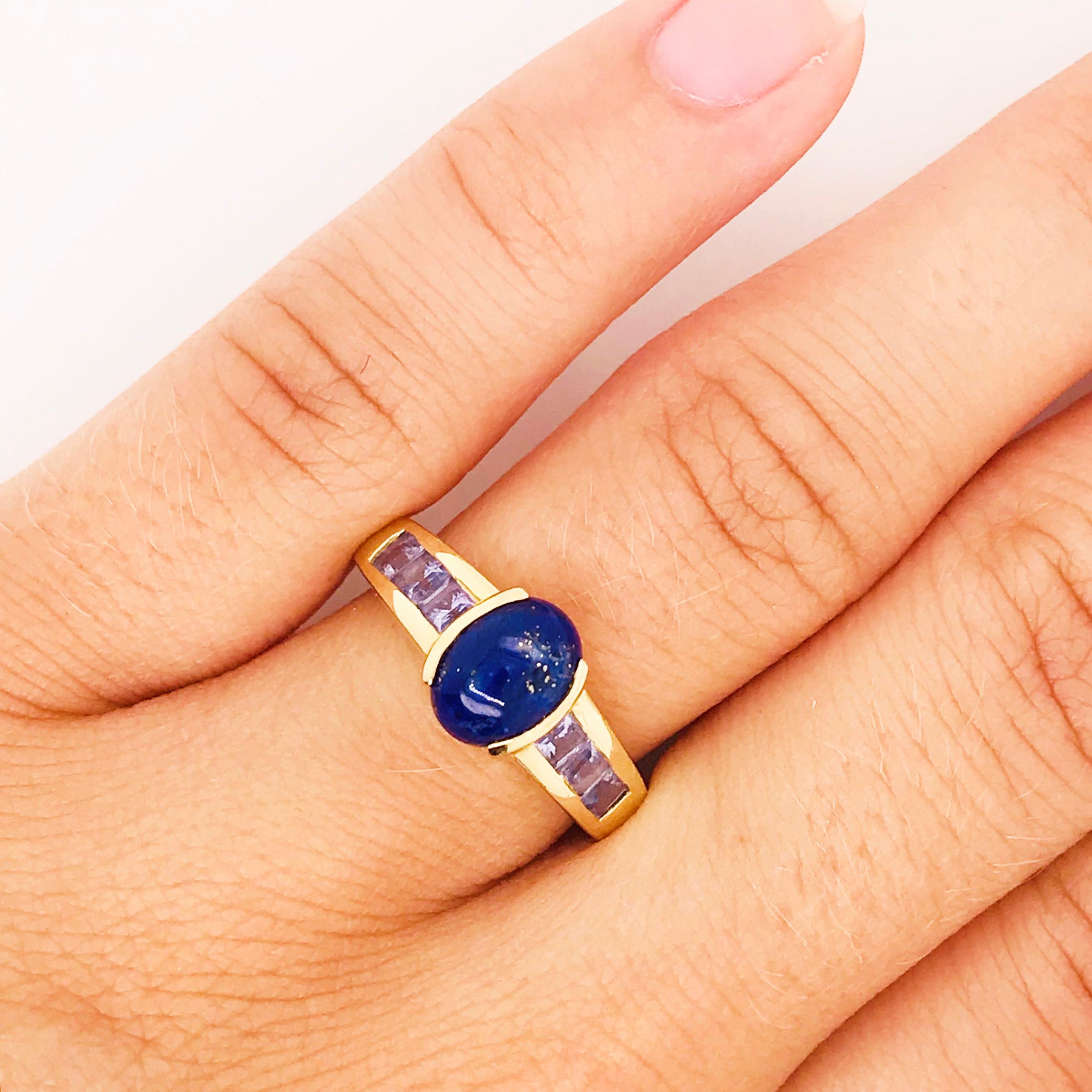 Striking blue lapis in bold yellow gold. The unique ring has a custom design with a genuine blue lapis gemstone set in the center. The lapis is a dark blue color that stands out on every hand. On each side of the center stone there are three