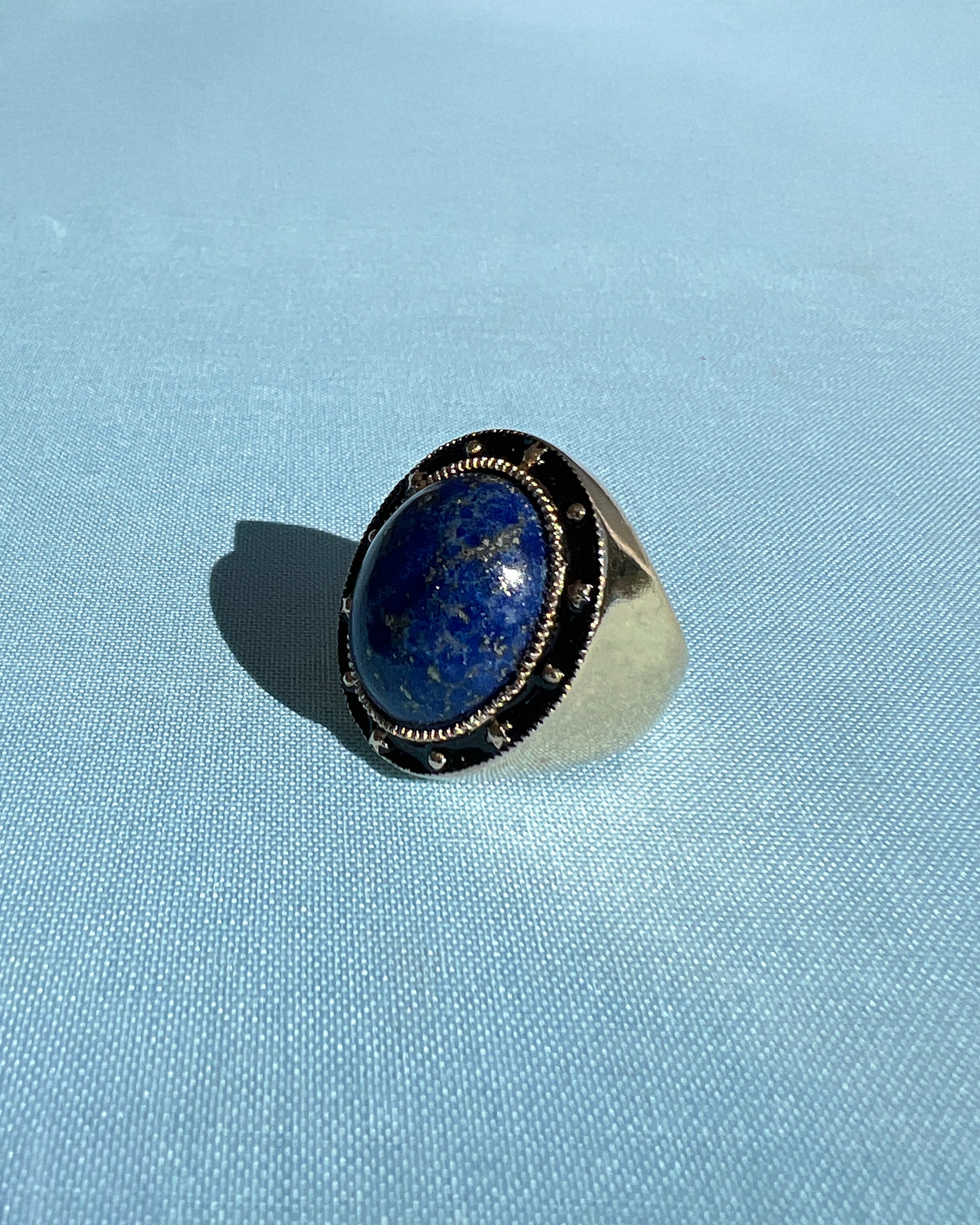 Lapislazuli-Ring aus schwarzer Emaille und 14-karätiger Goldplatte - viktorianisch inspirierter Cocktailring von J DAUPHIN

Der Lapislazuli-Cocktailring von J DAUPHIN verbindet moderne Handwerkskunst mit der zeitlosen Mystik viktorianischer