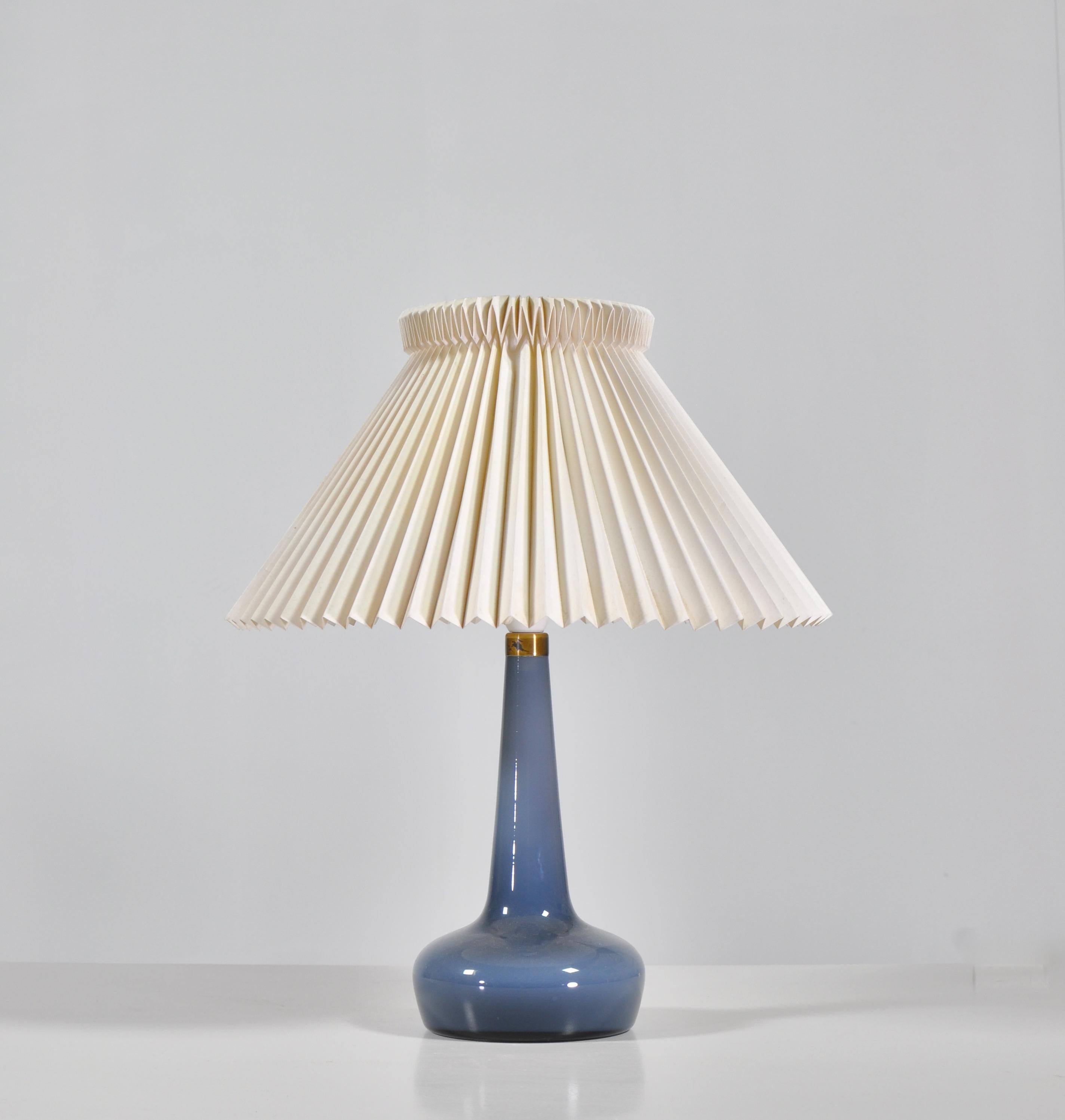 Wonderful table lamp model no. 311 designed by Esben Klint in 1949 for Le Klint, Denmark. This glass model was made at Holmegaard Glassworks, Copenhagen in the 1960s for Le Klint. The shade is the original hand folded acrylic shade.