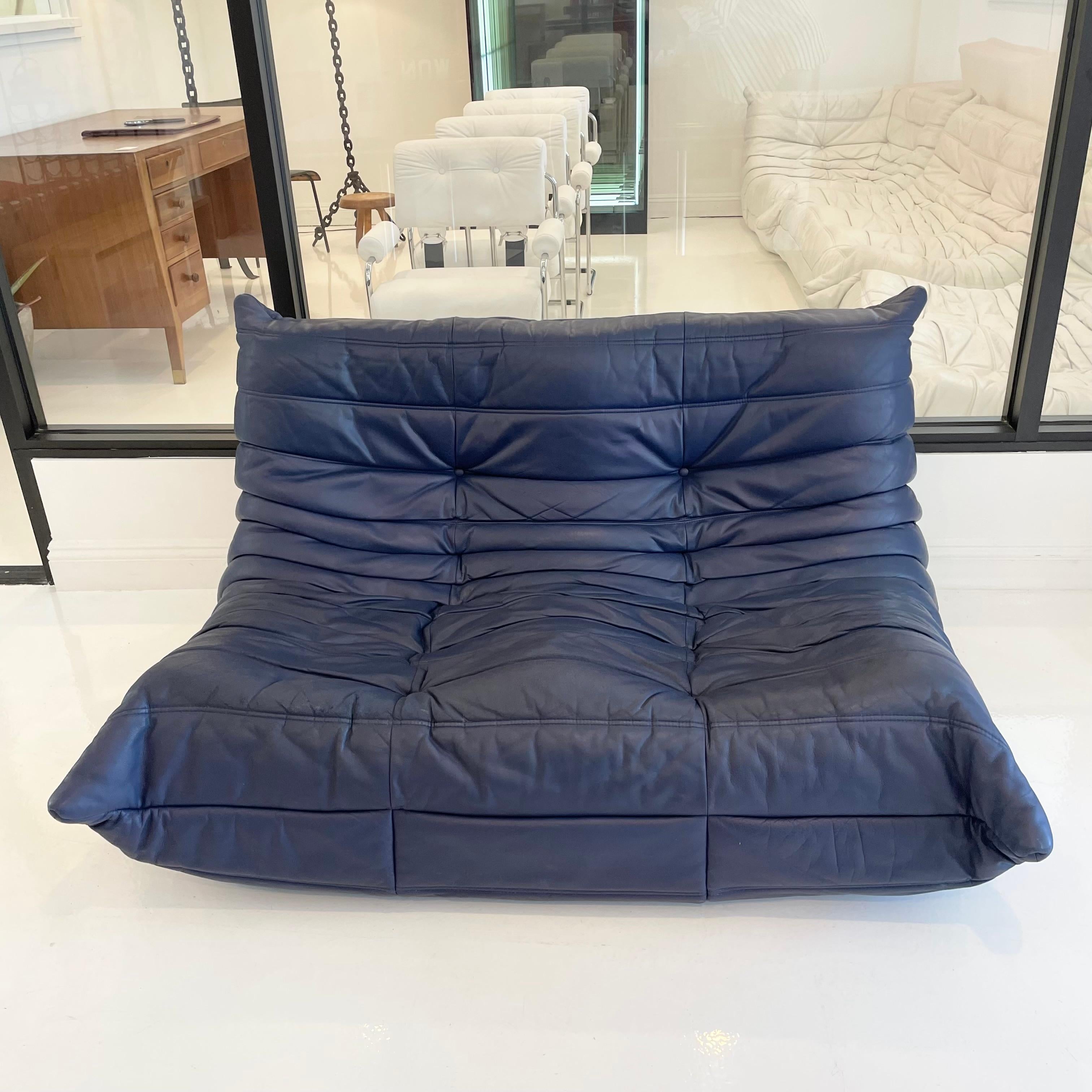 Classic French 2 seater Togo sofa by Michel Ducaroy for luxury brand Ligne Roset. Originally designed in the 1970s the iconic togo sofa is now a design classic. This sofa comes in its original blue leather and retains it's original fabric lining