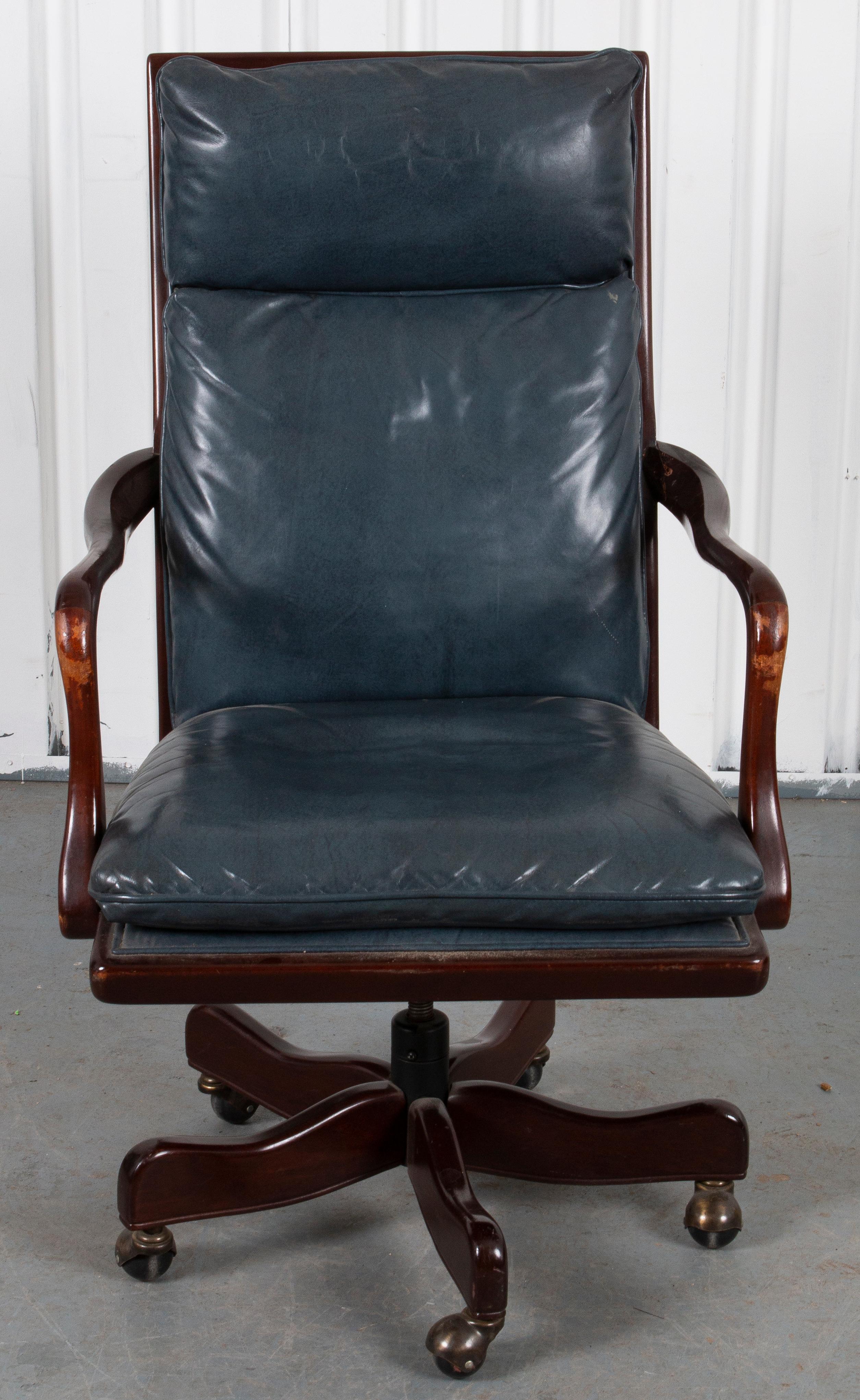 Armchair with wood frame over wheels, upholstered in blue leather.