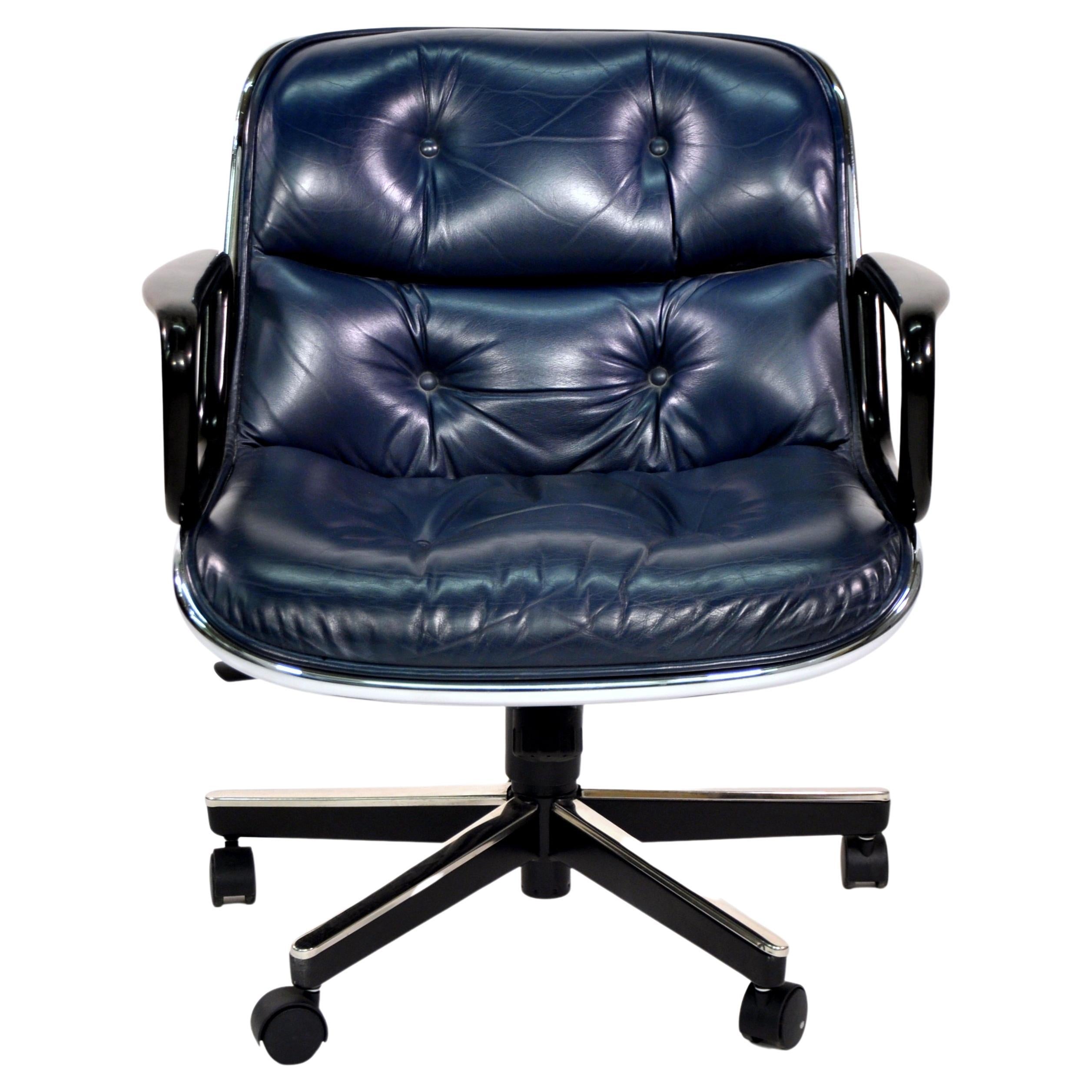 A vintage navy blue leather rolling office chair designed by Charles Pollock and manufactured by Knoll. The armchair has sleek lines, star base, chrome detail and the original dark blue leather.