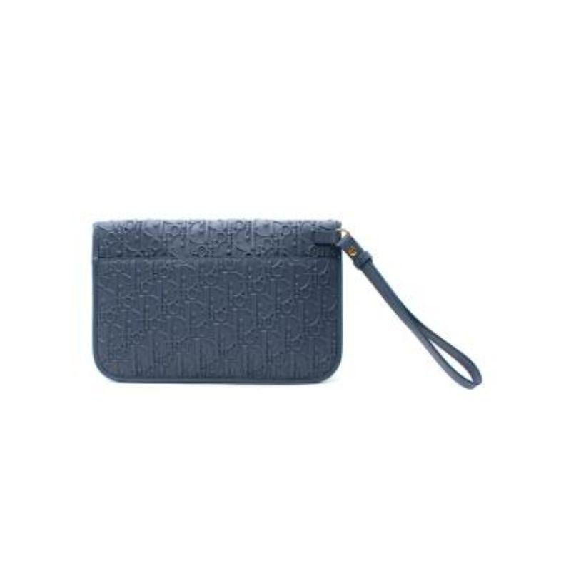 Dior blue leather Oblique embossed clutch bag
 

 - Mid blue leather with allover Oblique embossed pattern
 - Flap opening with popper 
 - Suede lined, with tonal leather card slots
 - Leather wrist strap 
 

 Materials
 Leather
 Suede 
 

 PLEASE
