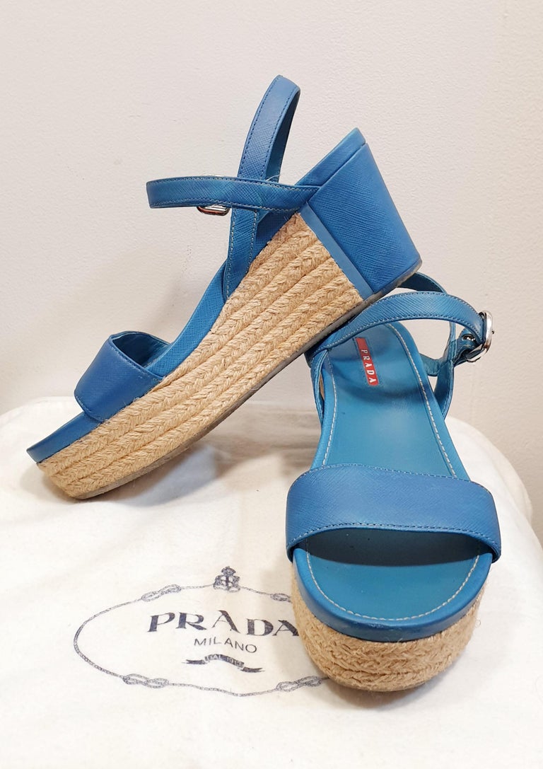 PLATFORM SANDALS PRADA in WHITE SAFFIANO LEATHER and NATURAL ESPARTO

Made In: Italy
Color: Blue
Materials: Leather 
Closure  Buckle
Marked Size: 39,5 Europe
Heel Wedge : 8cm 3,14 inches 
Platform Height:  3cm 1,18 inches

Orders welcome  all goods