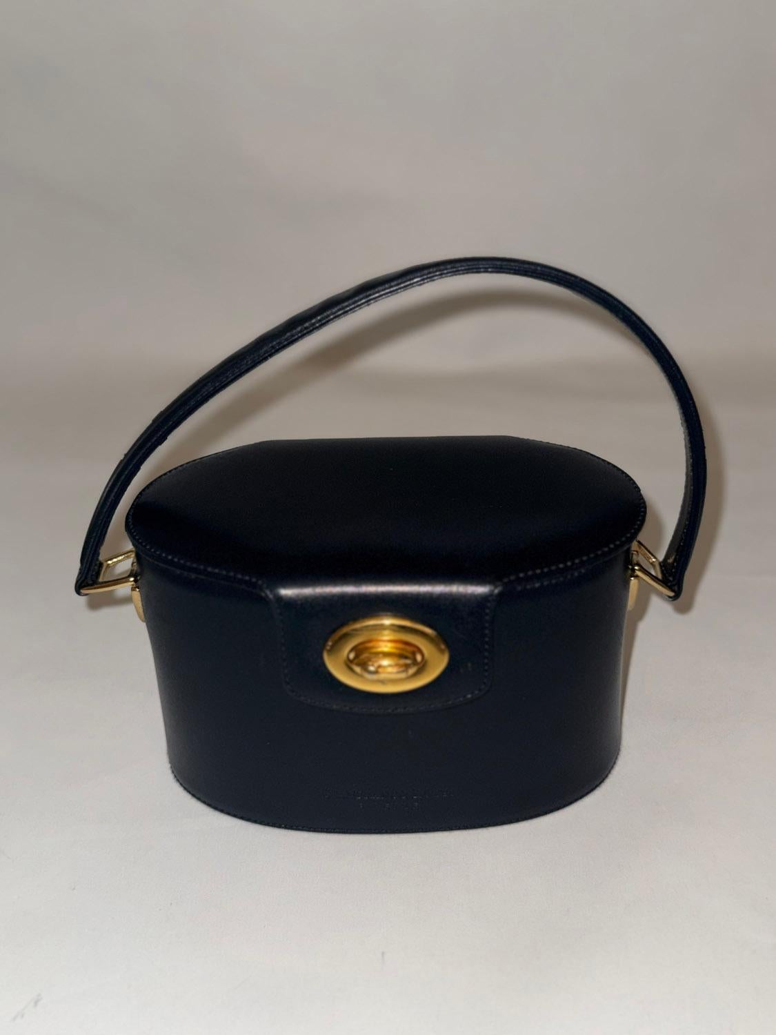 Una borsa con manico superiore chic e lussuosa di Gianfranco Lotti di Firenze. La borsa ha una forma ovale e un rivestimento in oro. Si chiude con una fibbia dorata e ha una tasca interna con zip. 
Misure: lunghezza 7 1/2'' , larghezza 4 1/4'' ,