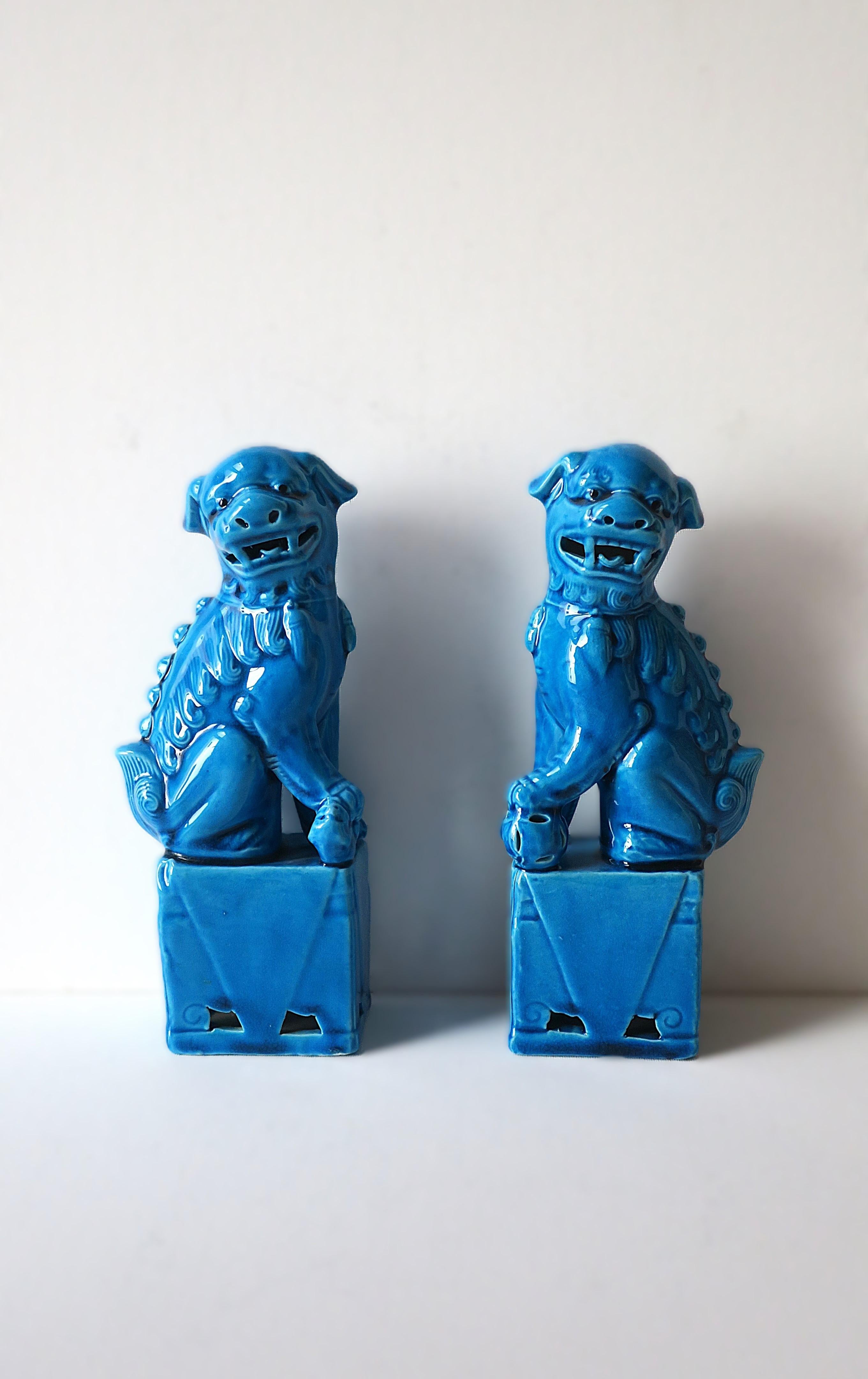 A beautiful pair of vintage ceramic lion foo dogs' decorative objects, circa mid-late 20th century, China. Pair are a beautiful turquoise hue. Great statement pieces/decorative object for a shelf, home library, end table, cocktail table, etc. Very
