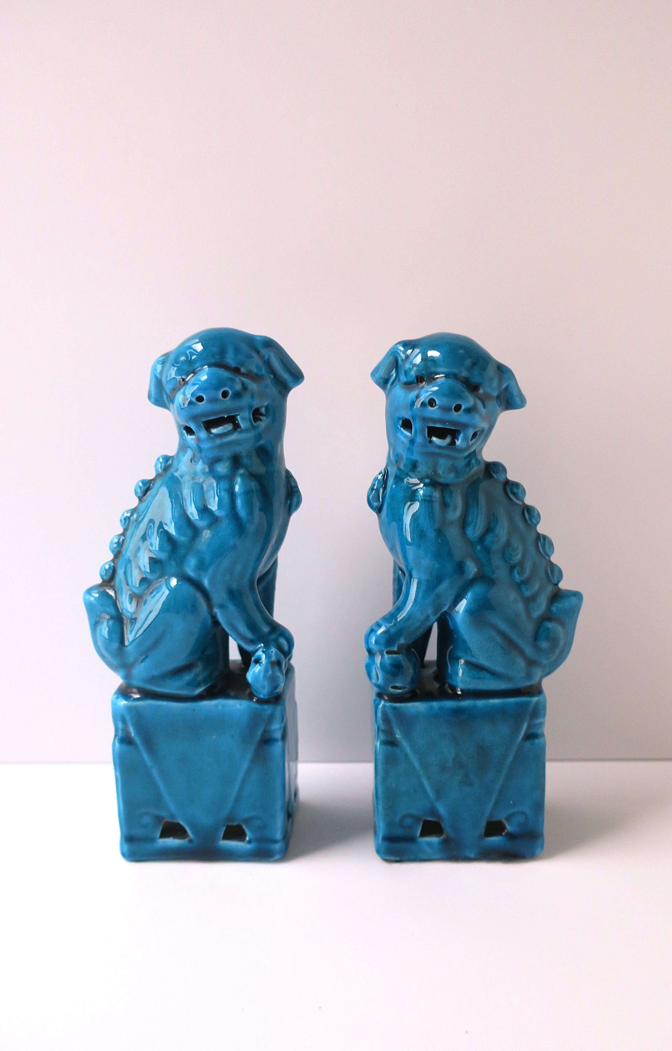 Ein Paar Deko-Objekte aus Porzellan, Keramik, Löwe und Hund, ca. Mitte des 20. Jahrhunderts, China. Die Paare haben einen schönen türkisen Farbton. Tolle Statement-Stücke/Deko-Objekte für ein Regal, eine Bibliothek, ein Wohnzimmer, einen