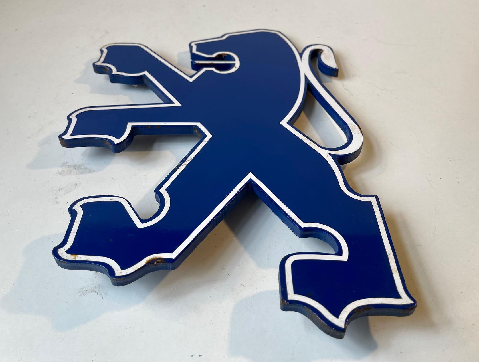 A 1990s lion logo for a Peugeot Dealership. Its made from enameled thick steel (1 cm) highlighted by a white acrylic band. Weight circa 3 kg's. Measurements: height: 31.5 cm, width: 21.5 cm.
