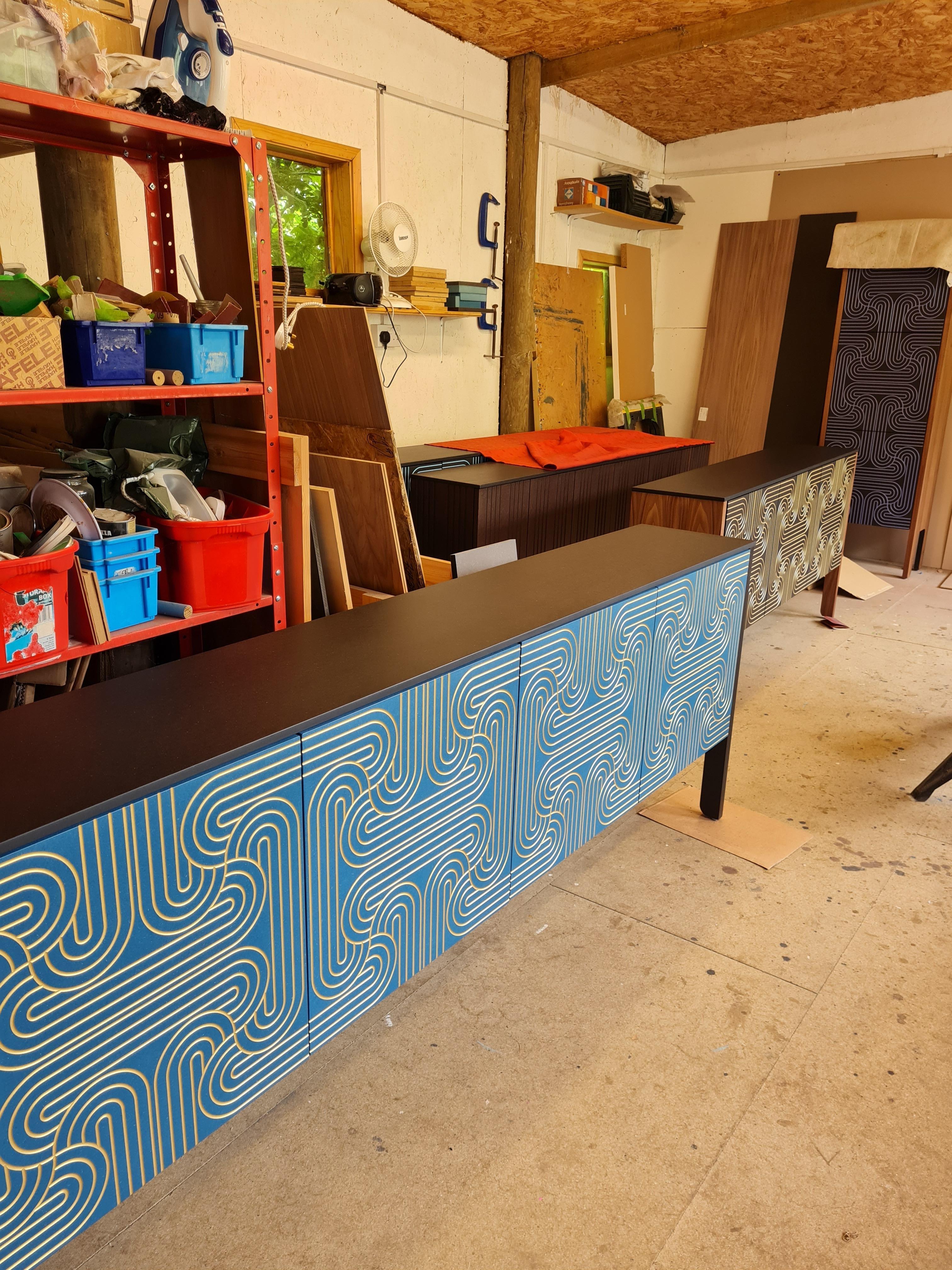 The stunning Loop Sideboards are available in a range of colours, this verdant Emerald version but also, bold Blue or striking Black.
The elegant Loop pattern is engraved onto the doors and handpainted in gold.
Each piece is finished by hand using
