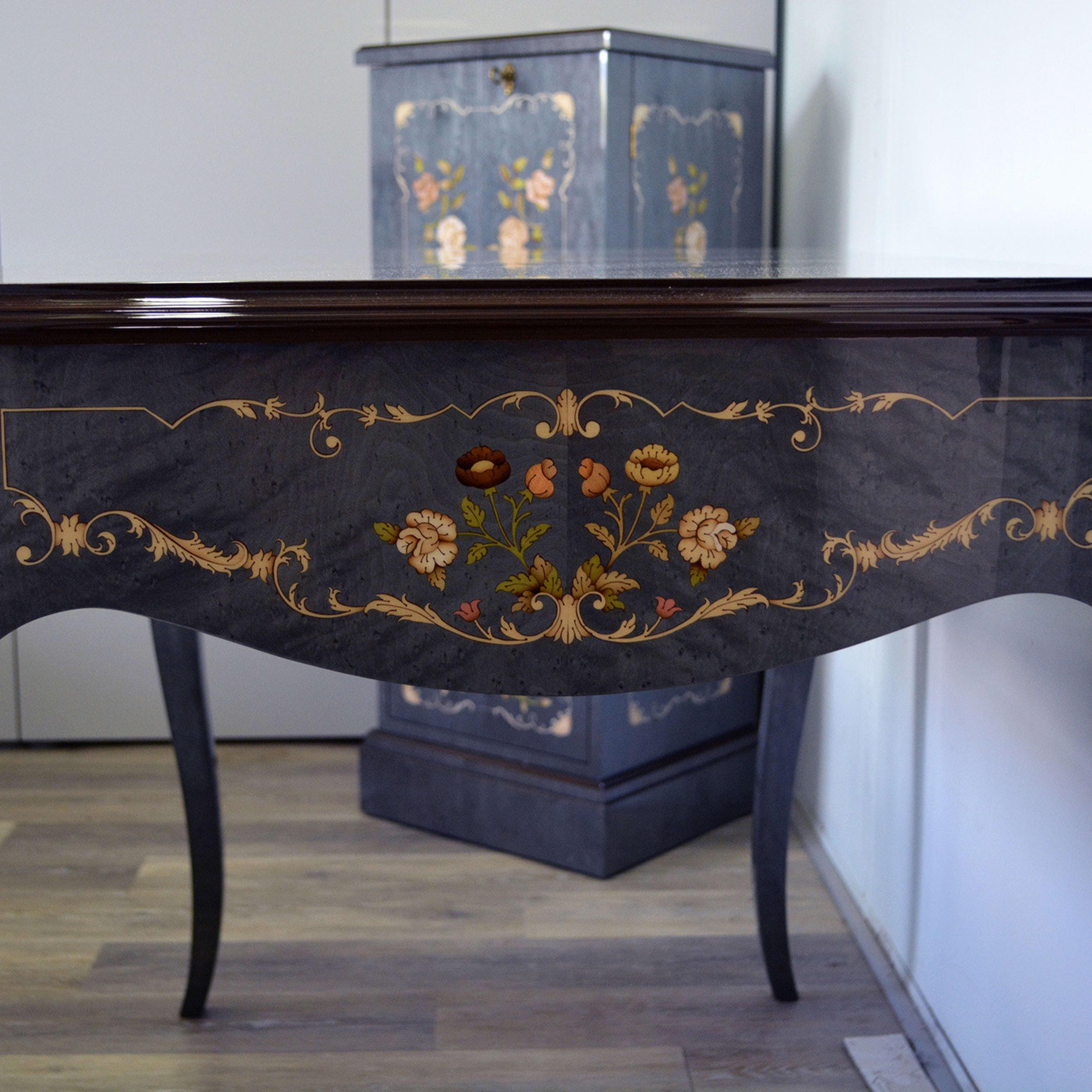 Masterfully executed using century-old techniques, Leone Intarsi's master artisans meticulously create the stunning floral motif of this desk in light blue-stained birdseye maple wood with a high-gloss finish. Carefully selecting different wood, the