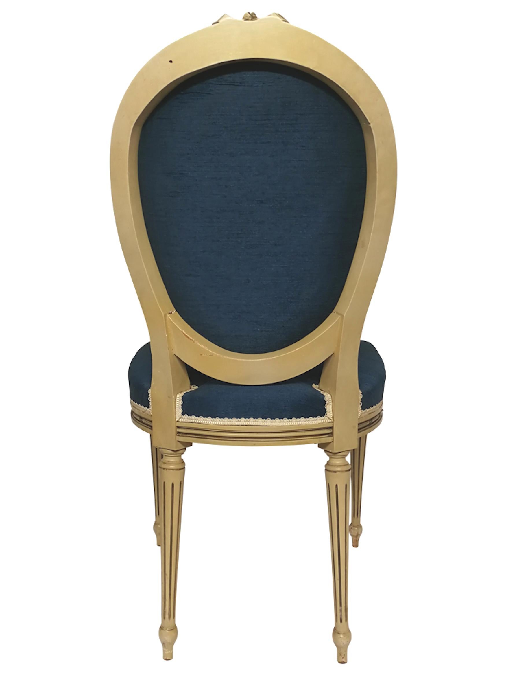 Louis XVI style medallion chair in painted wood and with blue silk upholstery. Fluted legs and typical decoration of the style with rosette and ribbon. Origin: France 
Period: First half of 20th century.
  