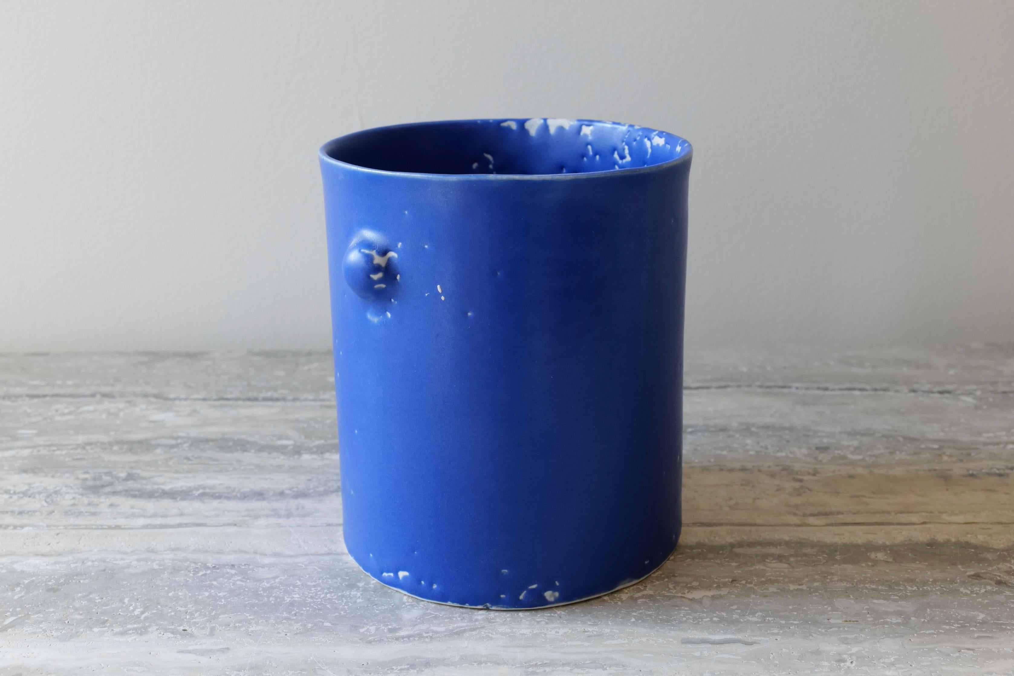 Ce vase est coulé à la main en porcelaine et émaillé d'une riche glaçure microcristalline au cobalt qui présente une belle texture lâche et craquelée sur toute la surface du récipient. Le motif des 