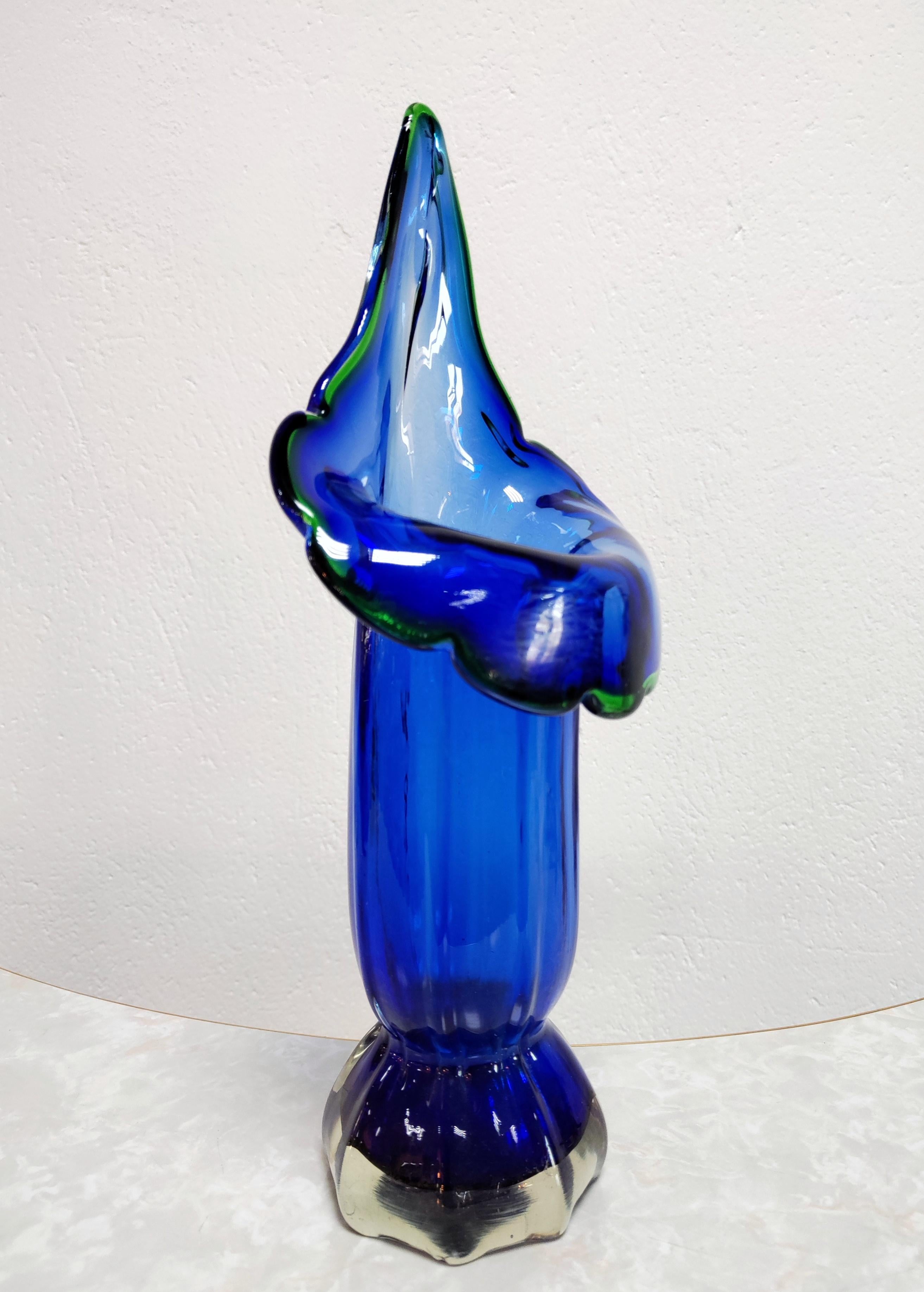 In dieser Auflistung finden Sie eine sehr seltene und atemberaubende, große mundgeblasene Murano-Glas-Vase in kobaltblauem, dickem Glas, mit dem grünen Rand um die Blüte, geformt als Calla Lily. Die elegante Form und die leuchtende Farbe machen ihn