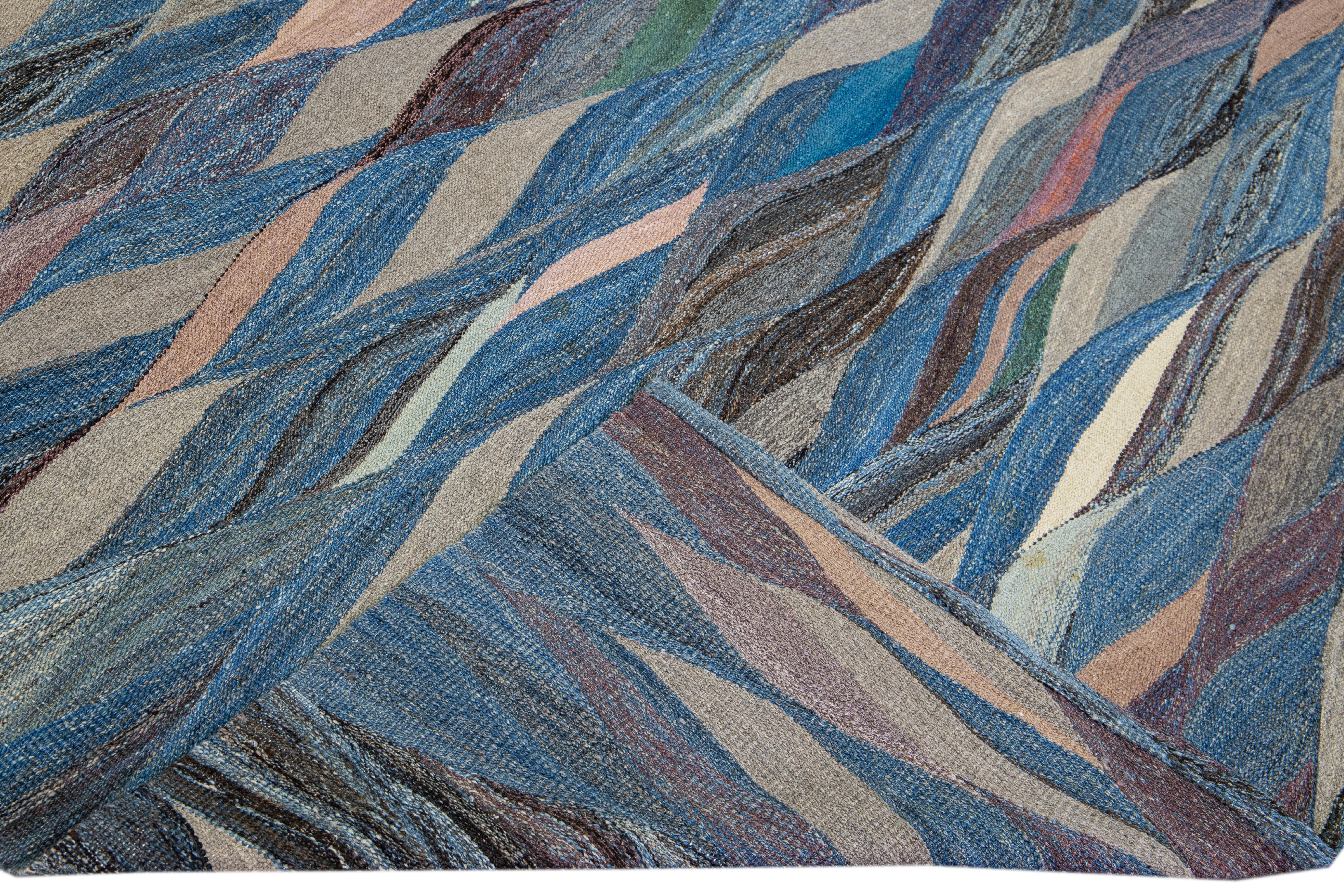 Schöner moderner flachgewebter Kelim aus handgefertigter Wolle mit blauem Feld. Dieser Kilim-Teppich hat mehrfarbige Akzente in einem wunderschönen abstrakten expressionistischen Design.

Dieser Teppich misst: 11'.8