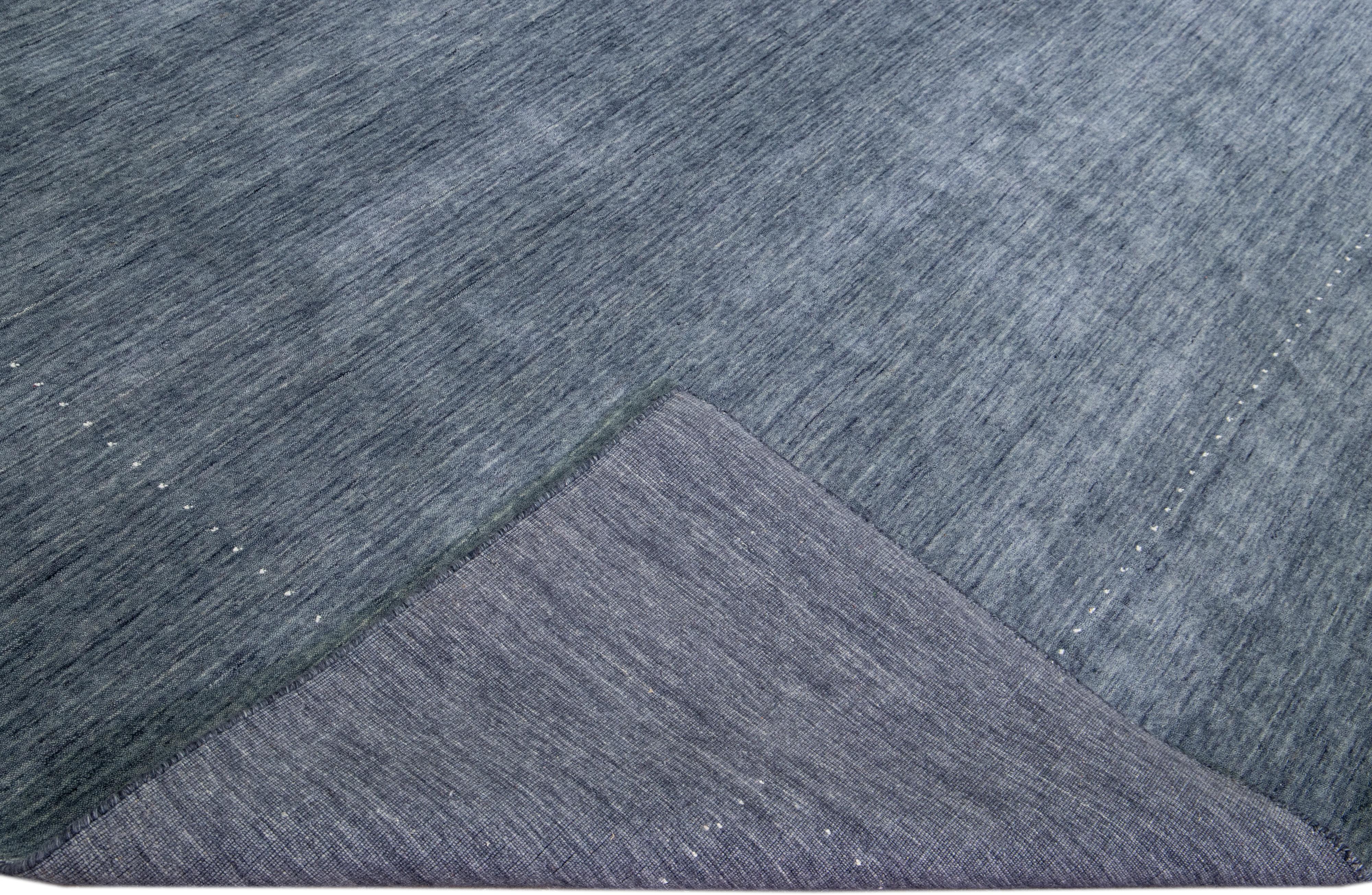 Schöner moderner Gabbeh-Stil Hand-Loom Wollteppich mit einem blauen Feld. Dieser Teppich im Gabbeh-Stil hat weiße Akzente in einem herrlichen geometrischen Minimal-Design.

Dieser Teppich misst: 10'4 x 13'10