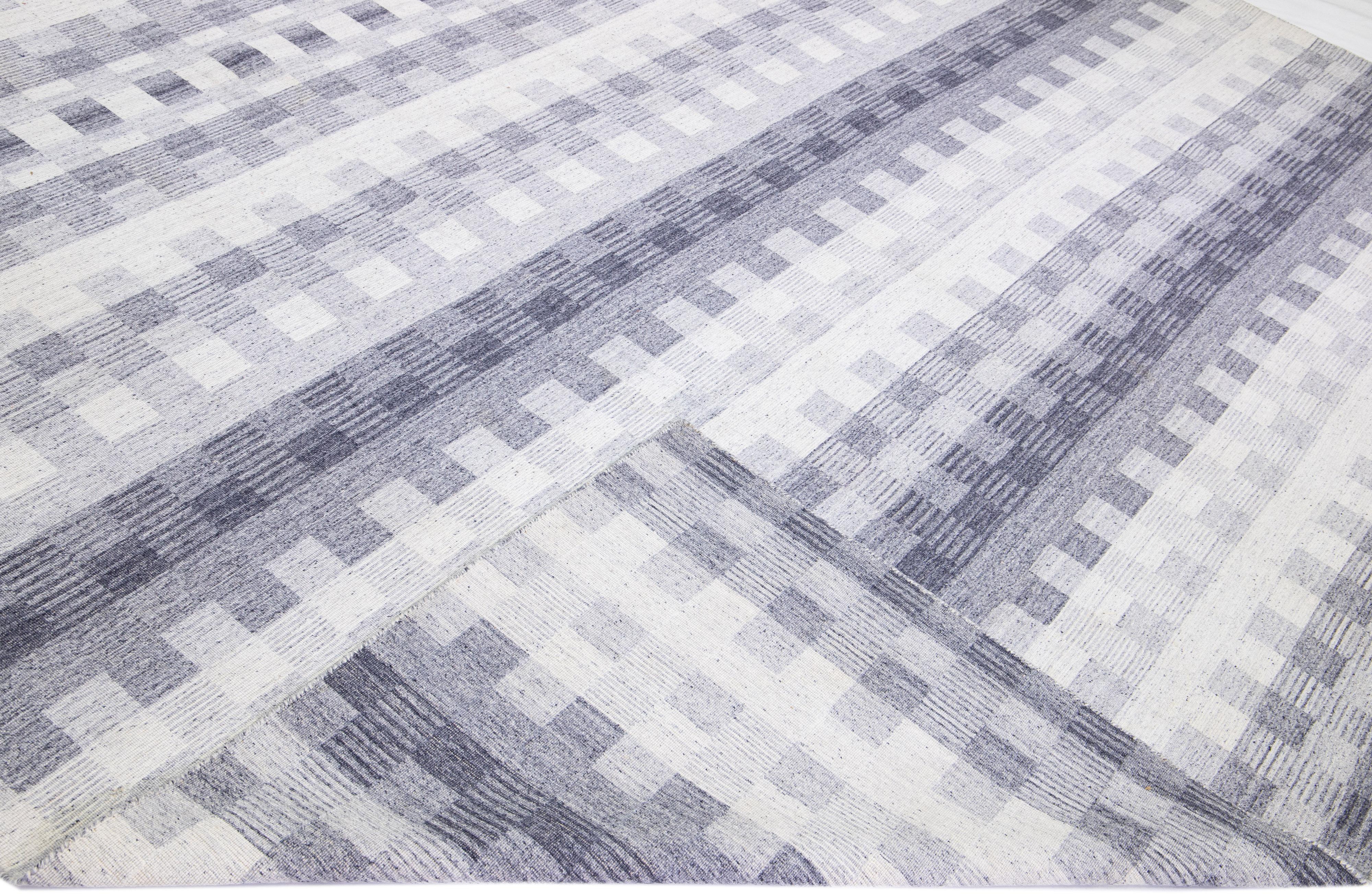 Beautiful modern Kilim flat-weave wool rug with a gray and ivory field featuring a gorgeous seamless geometric design.

This rug measures: 11'10
