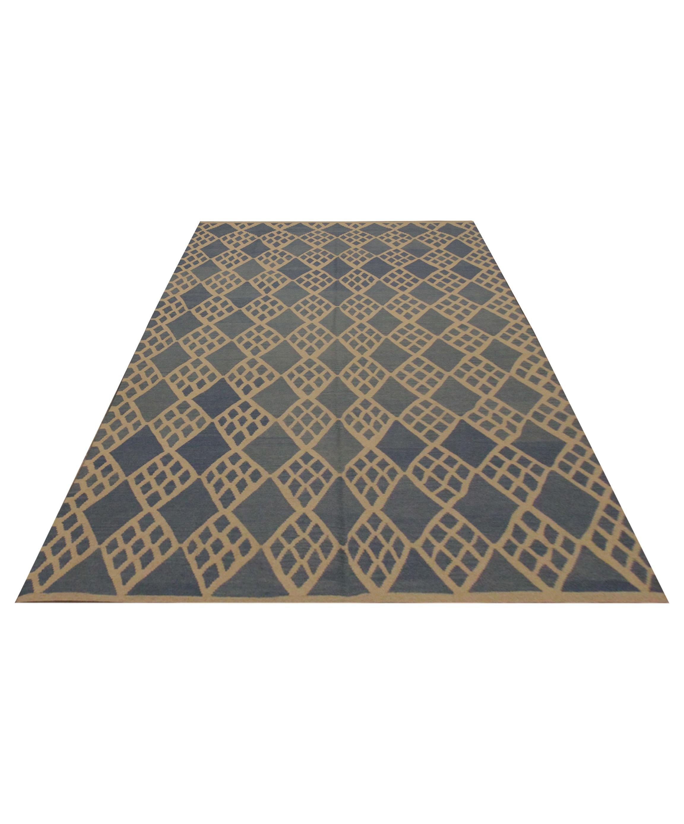 This blue and cream wool area rug is a handmade Kilim constructed in Afghanistan. The design features an all-over, symmetrical, geometric pattern similar to the interior of the Scandinavian colour palette. The bold design and subtle colour palette
