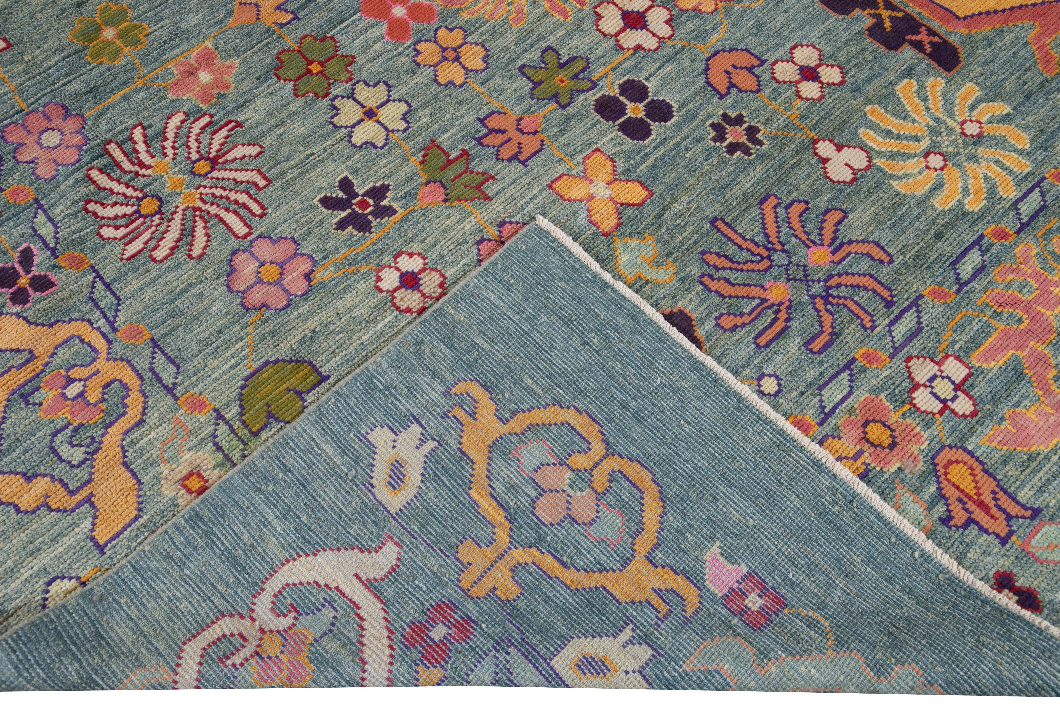 Beautiful modern oversize Oushak hand knotted wool rug with a blue field. This Oushak rug has multi-color accents all-over a gorgeous botanical floral design. 

This rug measures 12'4
