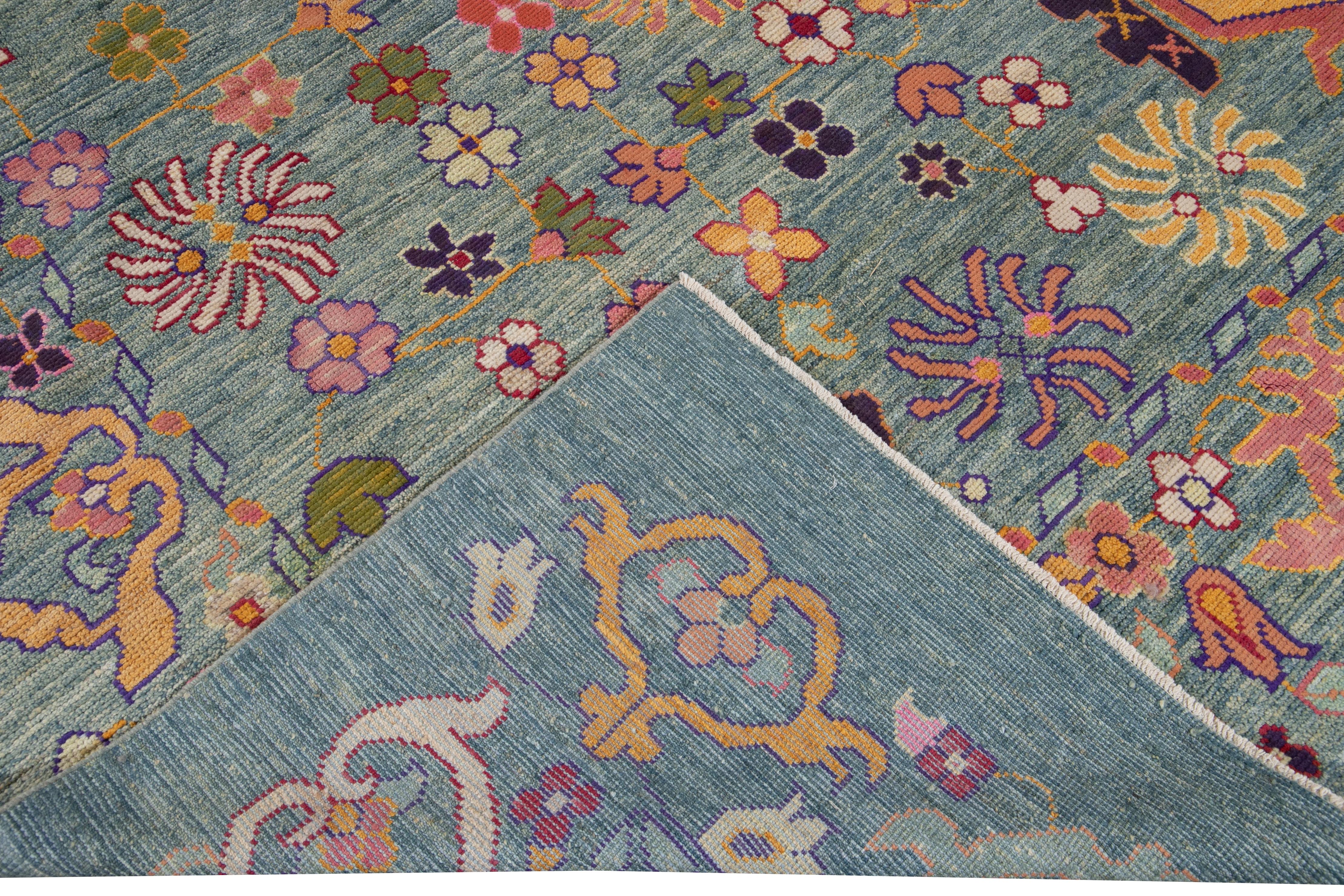 Schöner moderner, übergroßer, handgeknüpfter Oushak-Wollteppich mit blauem Feld. Dieser Oushak-Teppich hat mehrfarbige Akzente, die sich über ein wunderschönes botanisches Blumenmuster erstrecken. 

Dieser Teppich misst 12'4