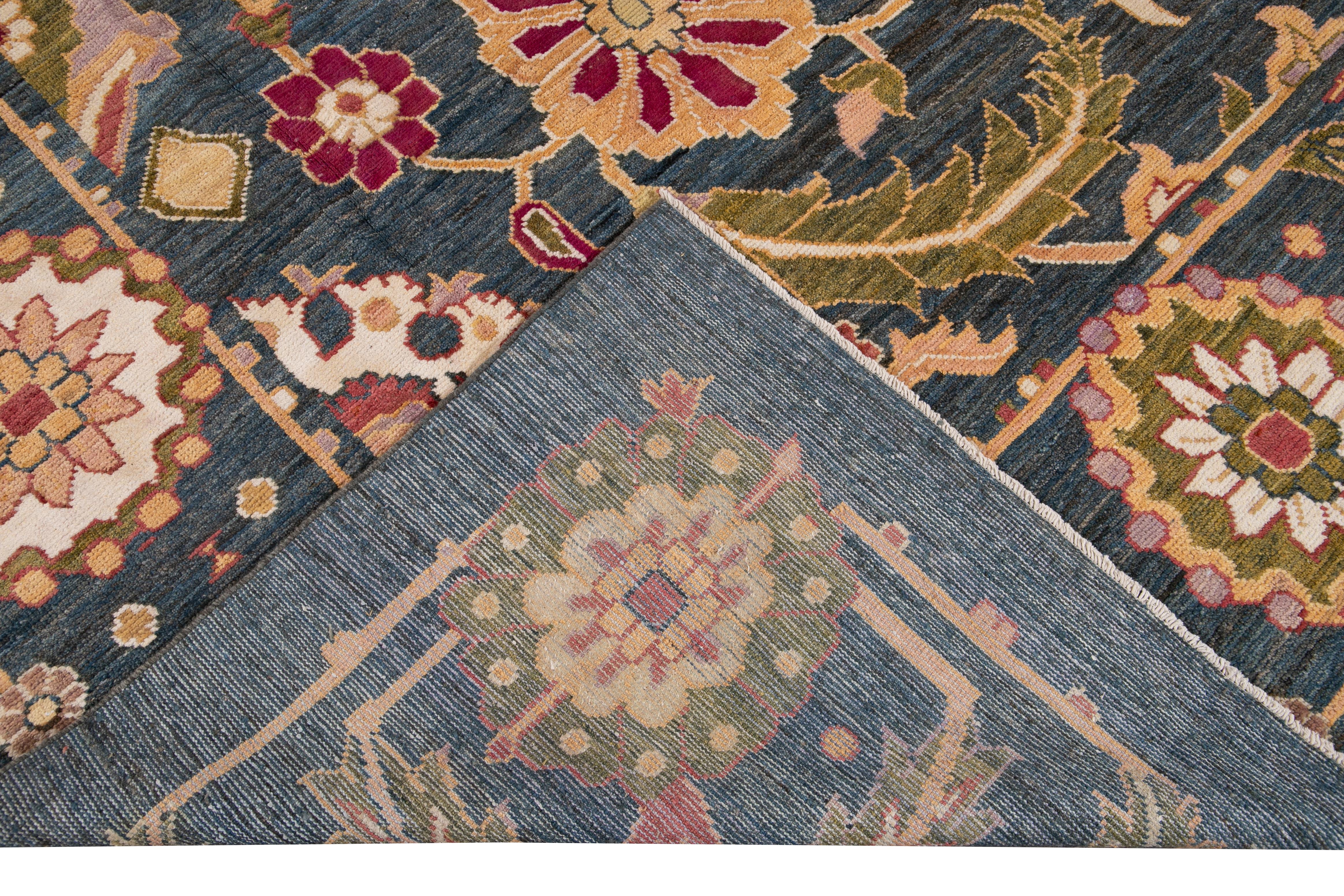 Beautiful modern oversize Oushak hand knotted wool rug with a navy-blue field. This Oushak rug has pink, purple, peach, and green accents all-over a gorgeous botanical floral design. 

This rug measures 13'2