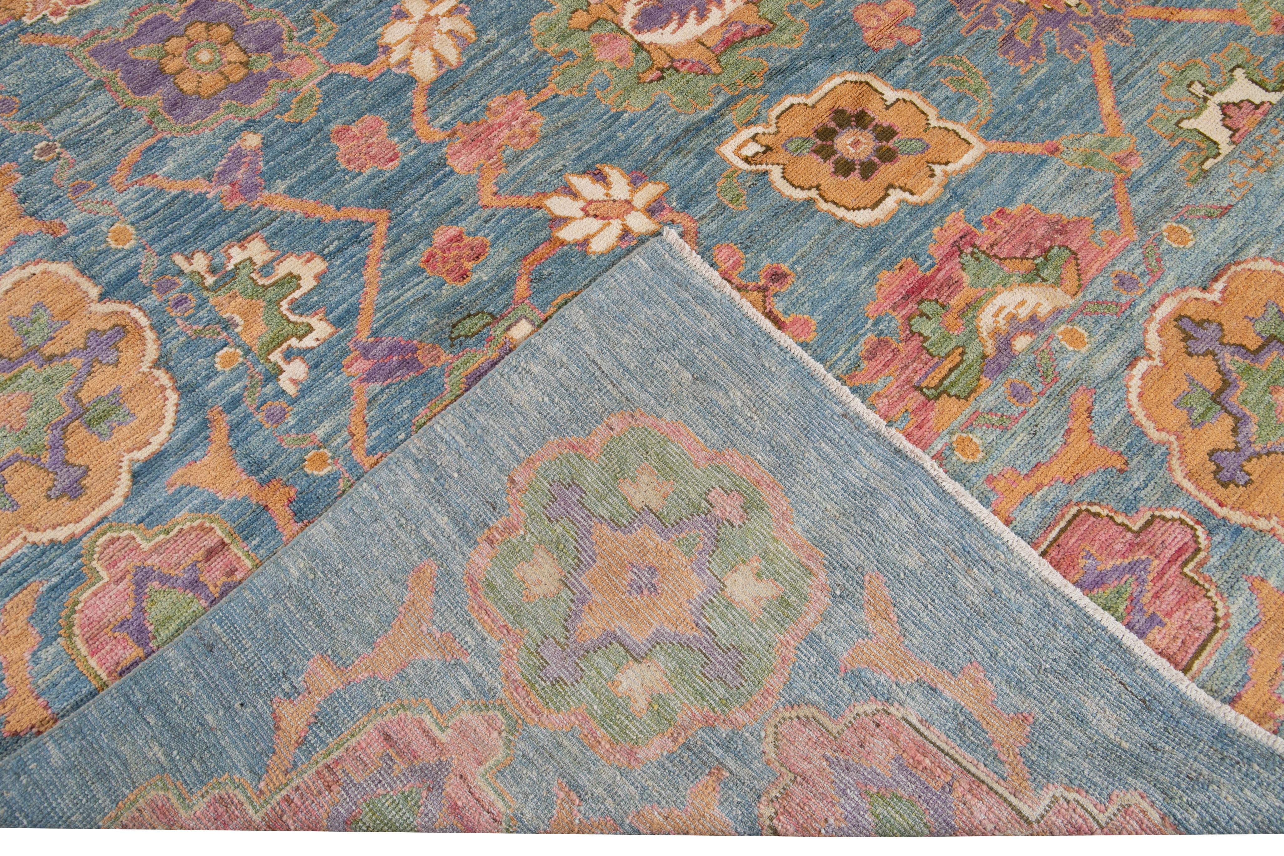 Beautiful modern oversize Oushak hand knotted wool rug with a blue field. This Oushak rug has multi-color accents all-over a gorgeous botanical floral design. 

This rug measures 11'9