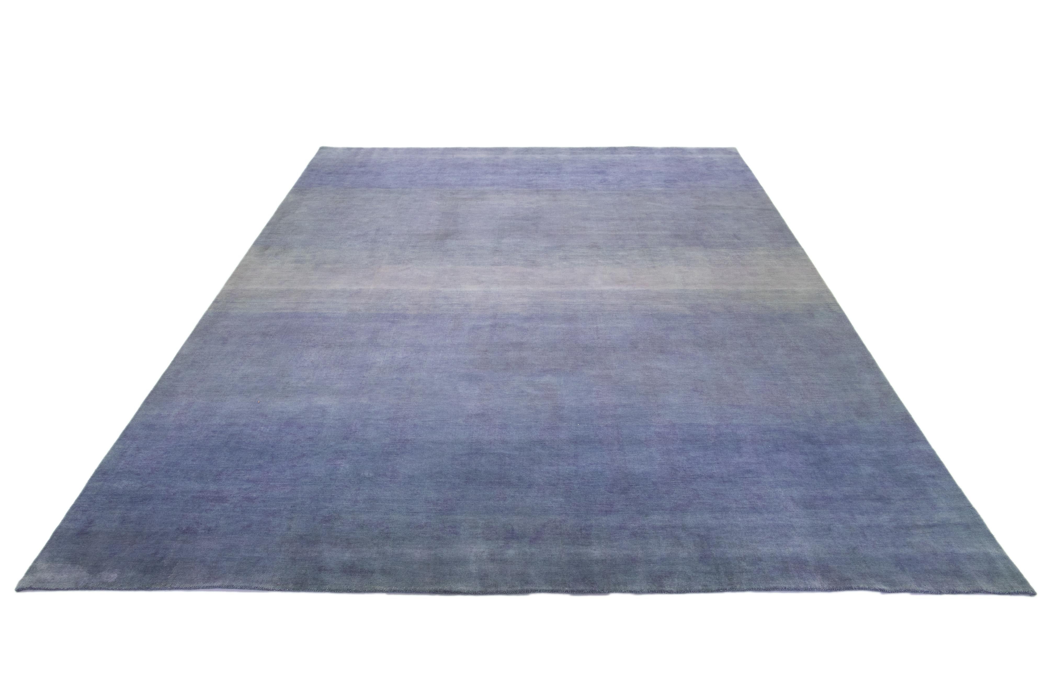 This modern Gabbeh rug is hand-loomed with a contemporary minimalist pattern. The blue base is accented with beige gradient color details.

This rug measures 12' x 14'9