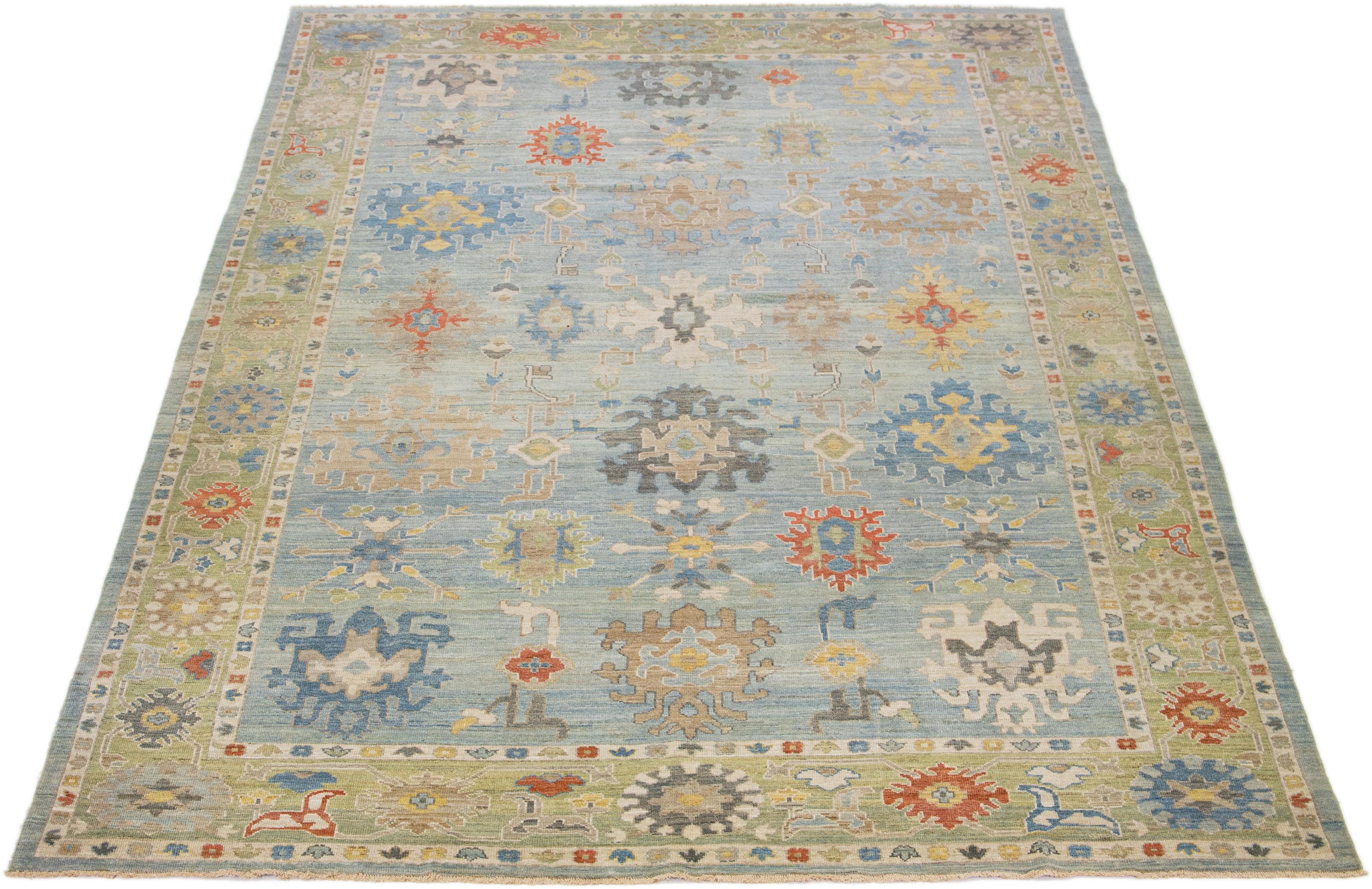 This modern reinterpretation of timeless Sultanabad design is beautifully manifested in an exquisitely hand-knotted wool rug, resplendent in its striking light blue shade. An intricate green border delineates its all-over floral embroidery,