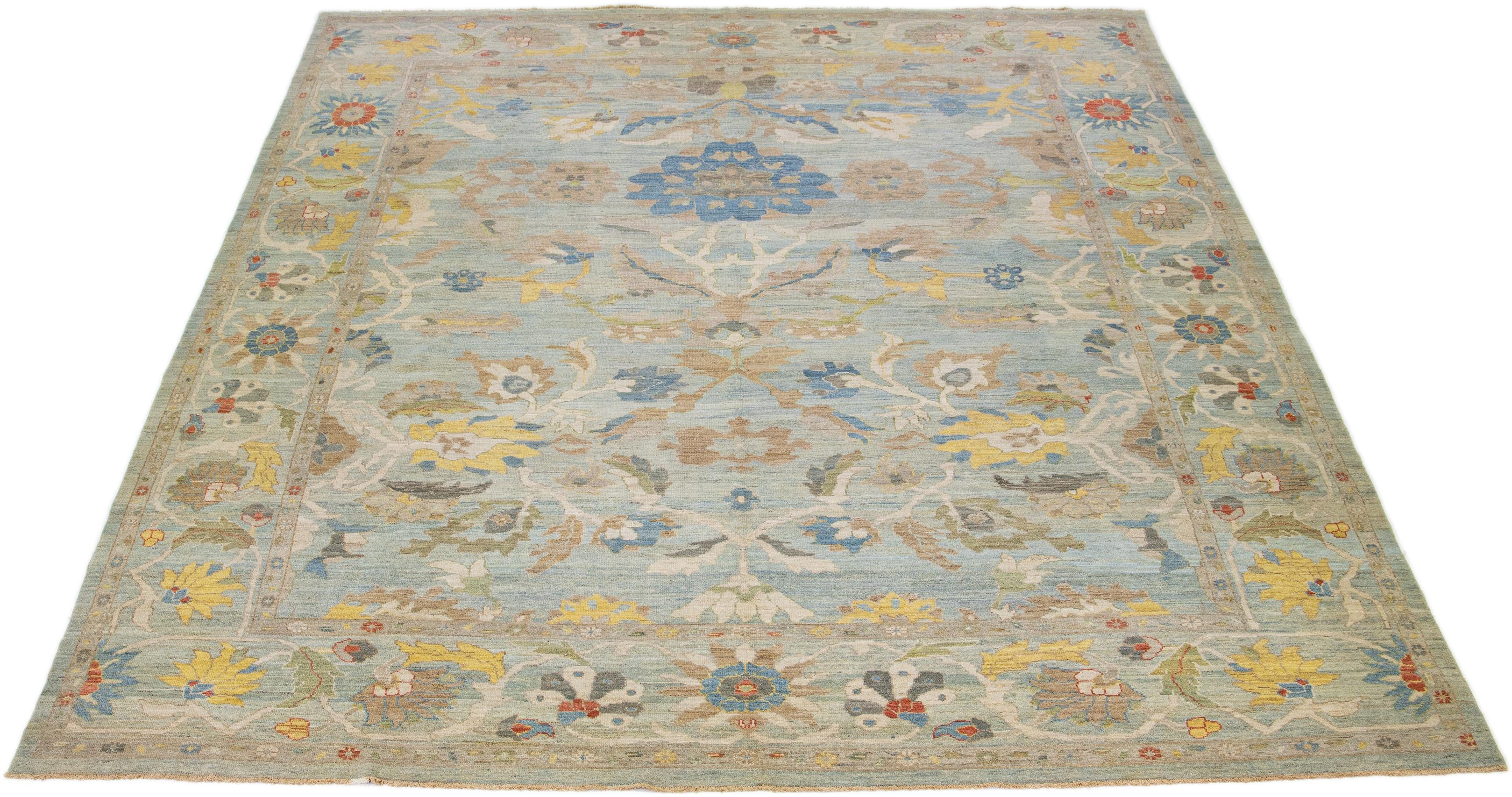 Diese moderne Neuinterpretation des zeitlosen Sultanabad-Designs zeigt sich in einem exquisiten, handgeknüpften Wollteppich, der in einem auffälligen hellblauen Farbton erstrahlt. Eine filigrane Bordüre umrandet die florale All-Over-Stickerei, die