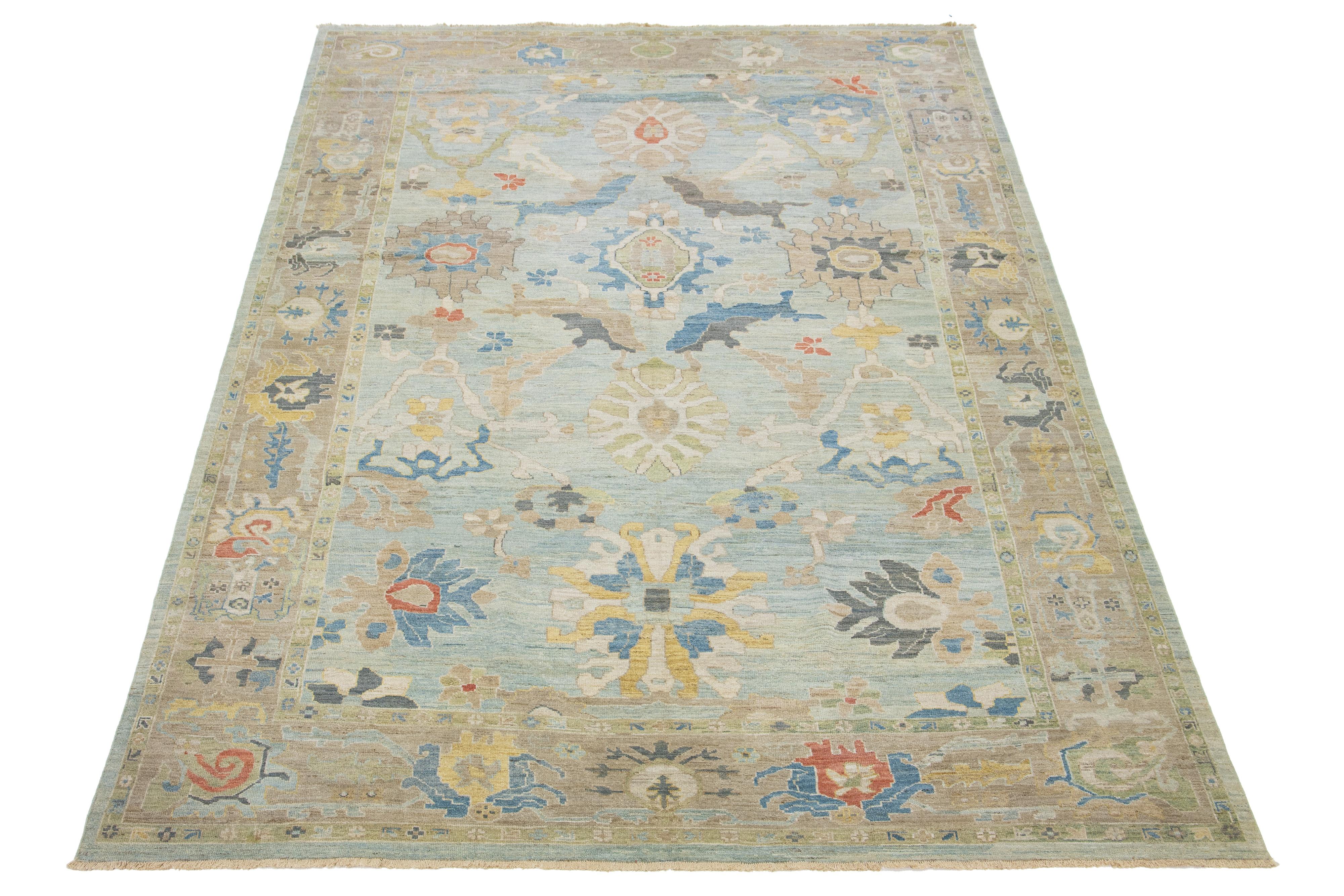 Dieser handgeknüpfte Wollteppich hat einen hellblauen Hintergrund, der mit gelben, beigen und grauen Allover-Motiven verziert ist.

Dieser Teppich misst 10'2'' x 15'2''.