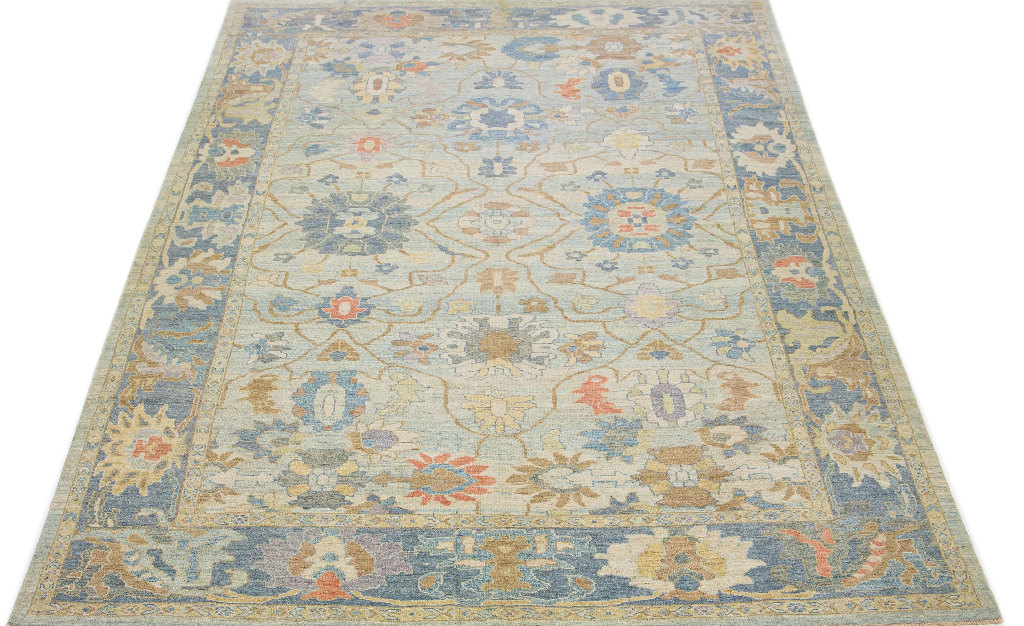This contemporary take on the traditional Sultanabad style is showcased in an exquisite hand-knotted wool rug with a striking light blue color. An intricately designed blue frame accentuates its all-over floral motif, adorned with multicolored
