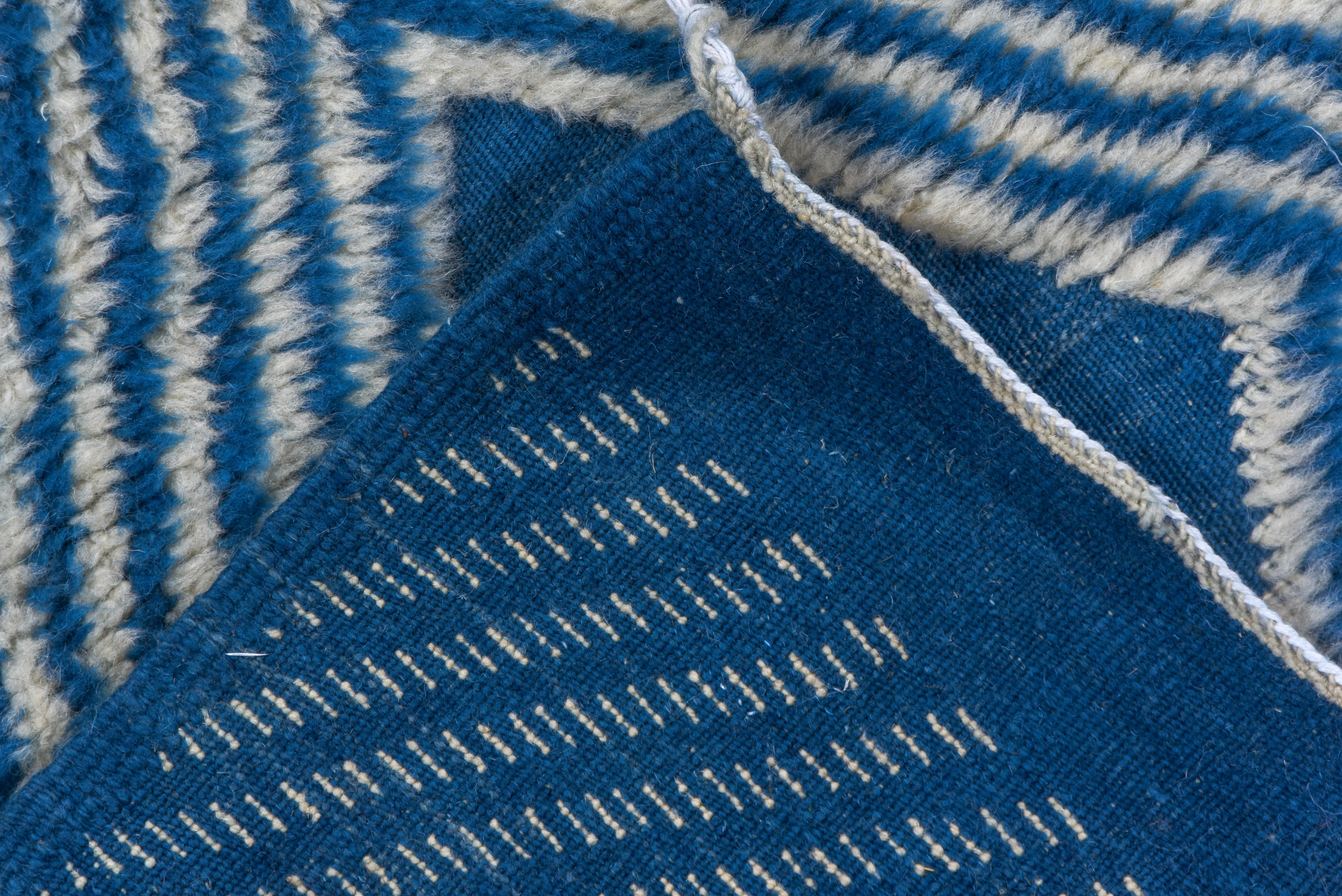 The crisp blue lozenges in two sizes and in a half-drop offset row pattern show dramatically against the close pinstriped blue and off-white ground. Plain blue flat-woven ends.