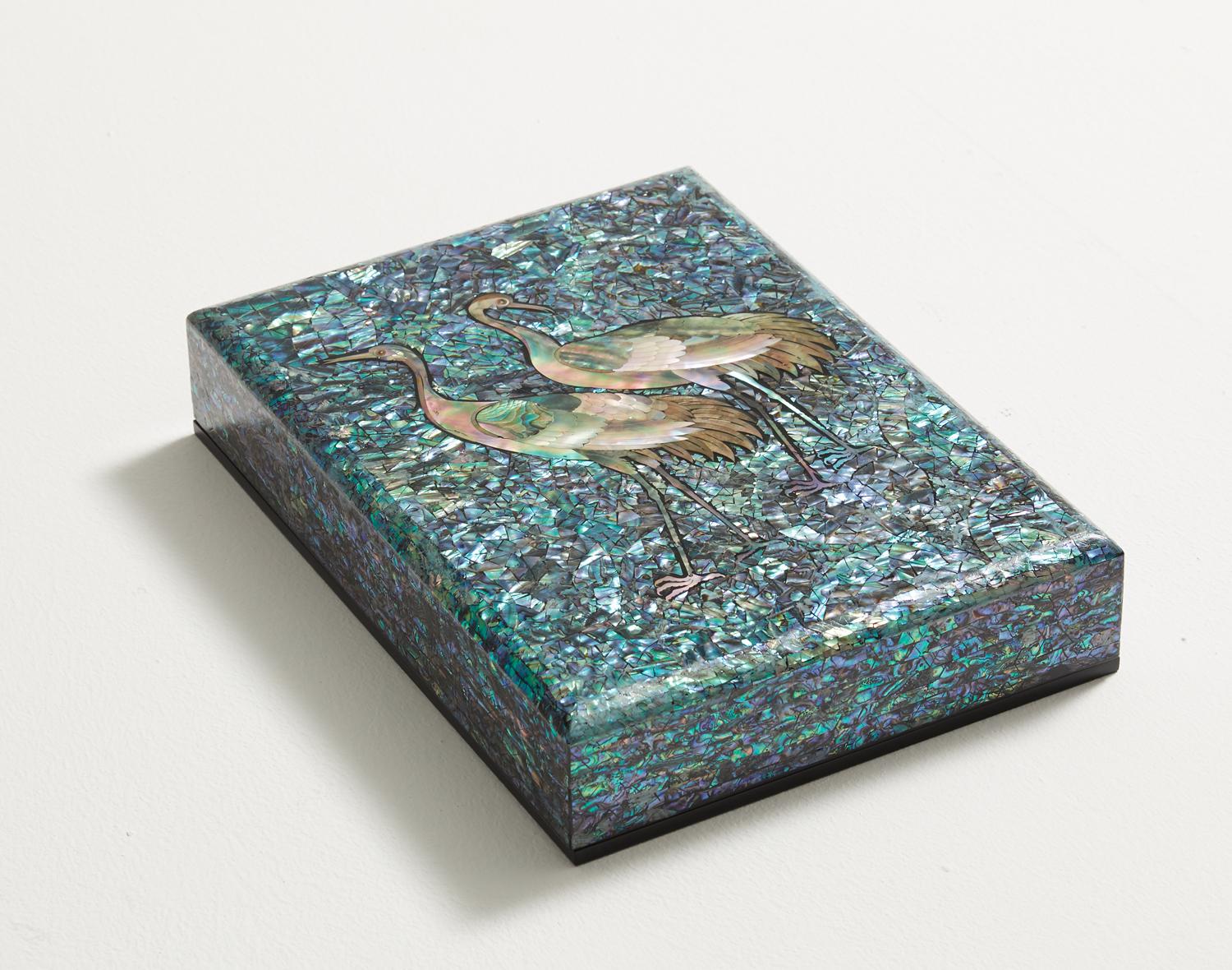 This artwork presents a wooden box inlaid with the image of cranes carved from mother of pearl. The sky is engraved with the blue shade of mother of pearl to highlight the profound mysteriousness of the cranes. The brilliant light shines gloriously
