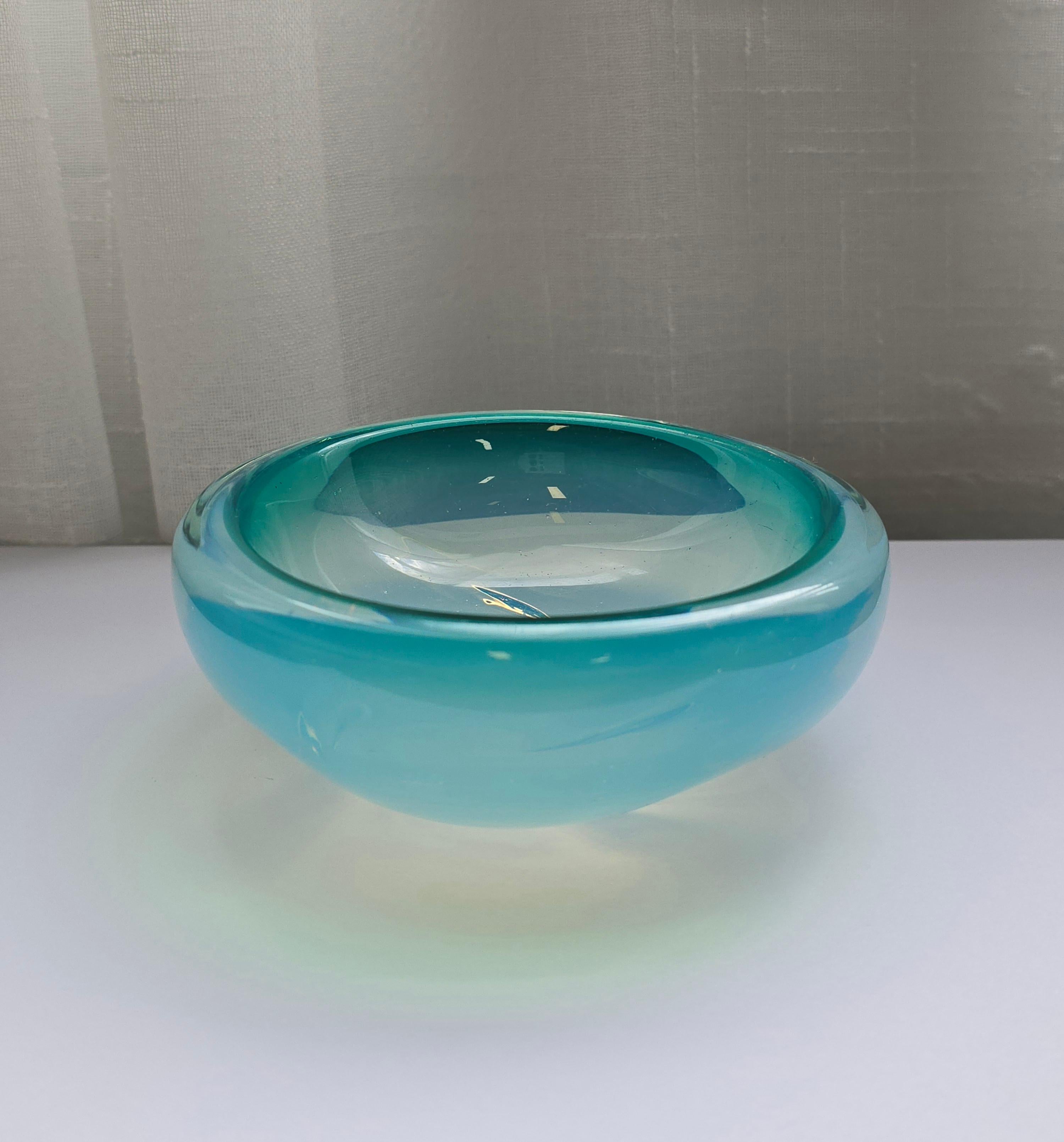 Incredibile ciotola decorativa di Murano in vetro artistico blu e verde. Questo pezzo decorativo è stato realizzato negli anni '60 a Murano. Questo piatto decorativo è in vetro artistico blu con note di verde. La forma è arrotondata e la miscela di