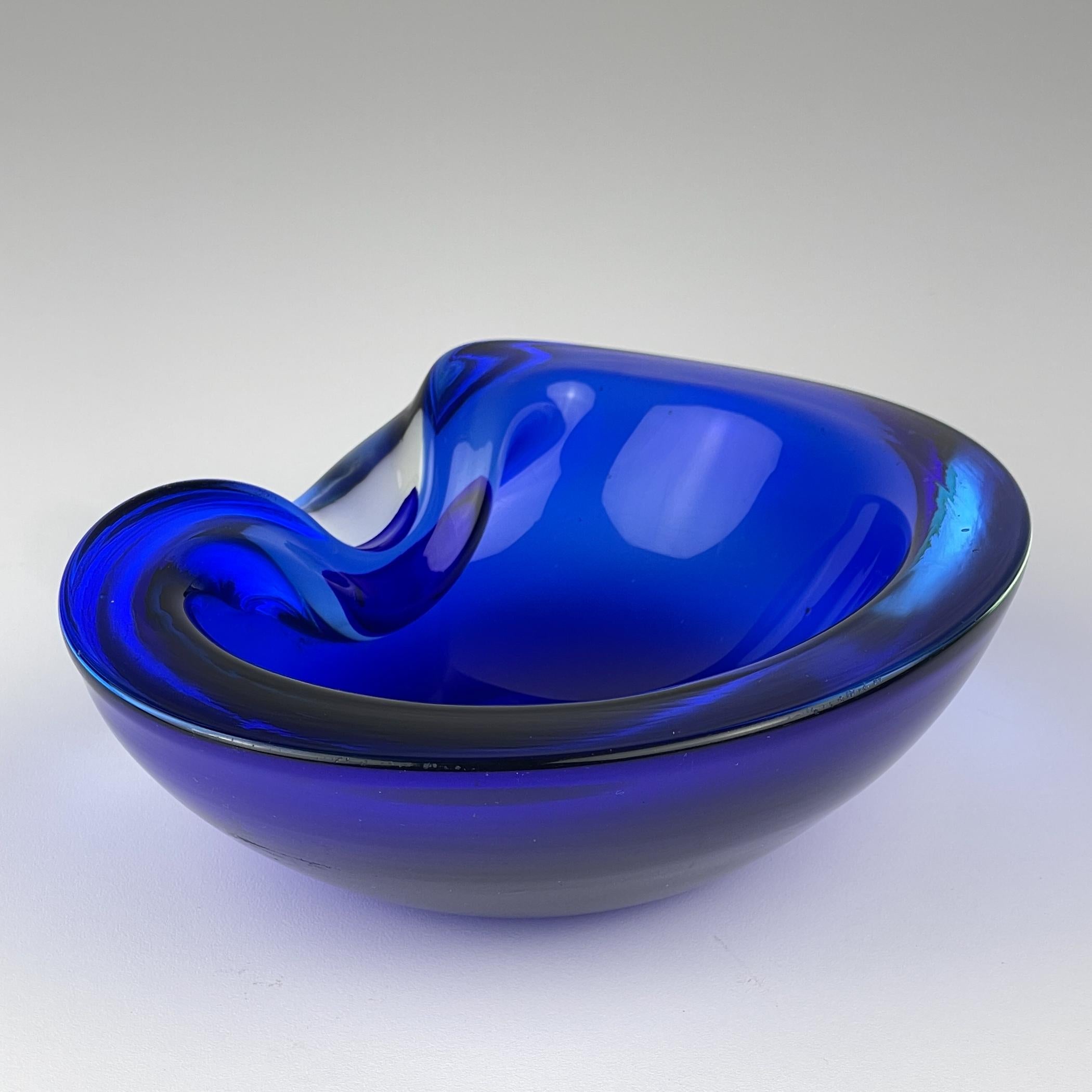 Posacenere vintage in vetro di Murano blu realizzato in Italia negli anni '80.

La ciotola è in buone condizioni vintage.

Dimensioni:
Larghezza: 17,5 cm / 6,9 pollici
Altezza: 6 cm
Profondità: 14 cm / 5,5 pollici
Peso: 1200 g

Offriamo una