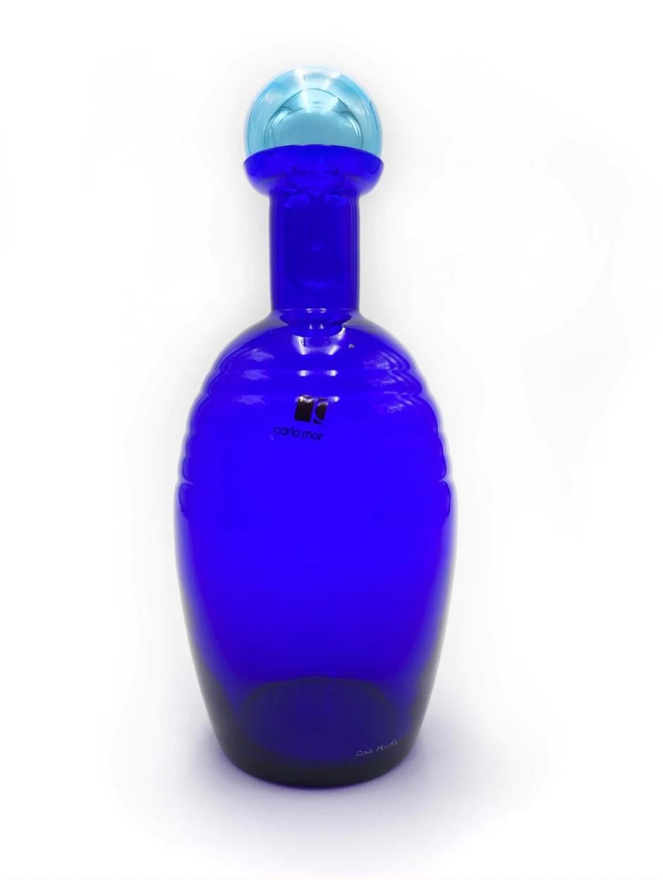 Blue Murano glass bottle, made by Carlo Moretti in the 1980s.

Measures: Ø cm 8, H cm 21

Carlo Nason, born in Murano in 1935 from one of the oldest glassmaking families on the island, he was a great master glassmaker. He grew up attending the