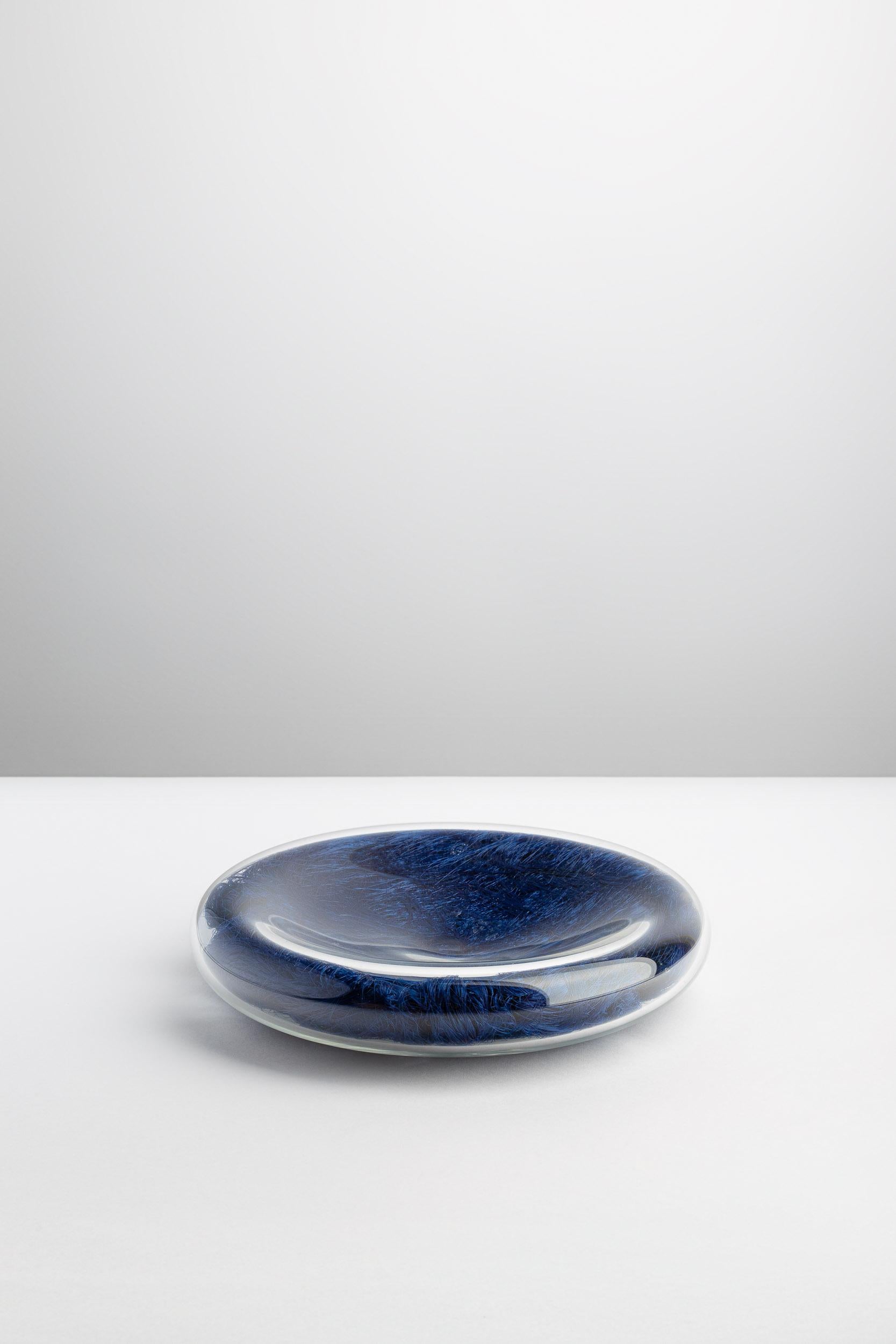 VELENI’s communicative and elegant Centerpiece CE-20db is a vanitas leading to reflection. This blown glass disc filled with microfibers catches the eye, making it wander among volumes, transparencies and roundness. However, why not see it as a