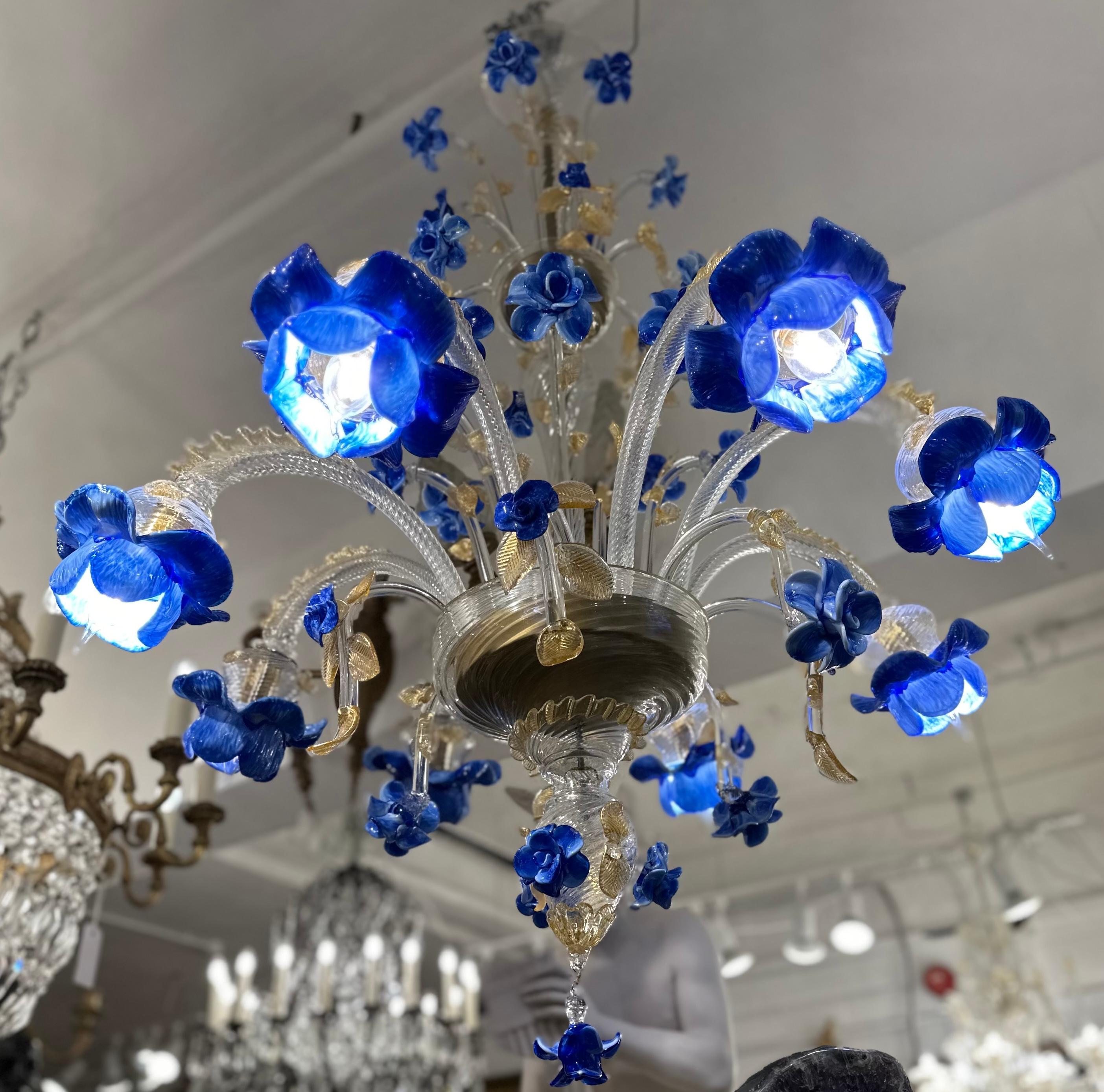 A dazzling blue, amber and gold murano glass chandelier, that is made with pure 24kt gold. Hand blown in Venice by skilled artisans this chandelier incorporates a delicate floral and foliage design. Murano glass is world renown, with a long history