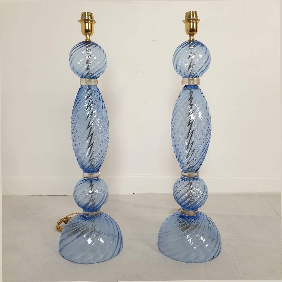Pair of Blue Murano glass Mid-Century Modern lamps, Seguso style Italy 1980s.
The neoclassical large table lamps are made of a light blue color Murano glass with clear-gold accents and brass mounts.
The lamps have one light each and have been