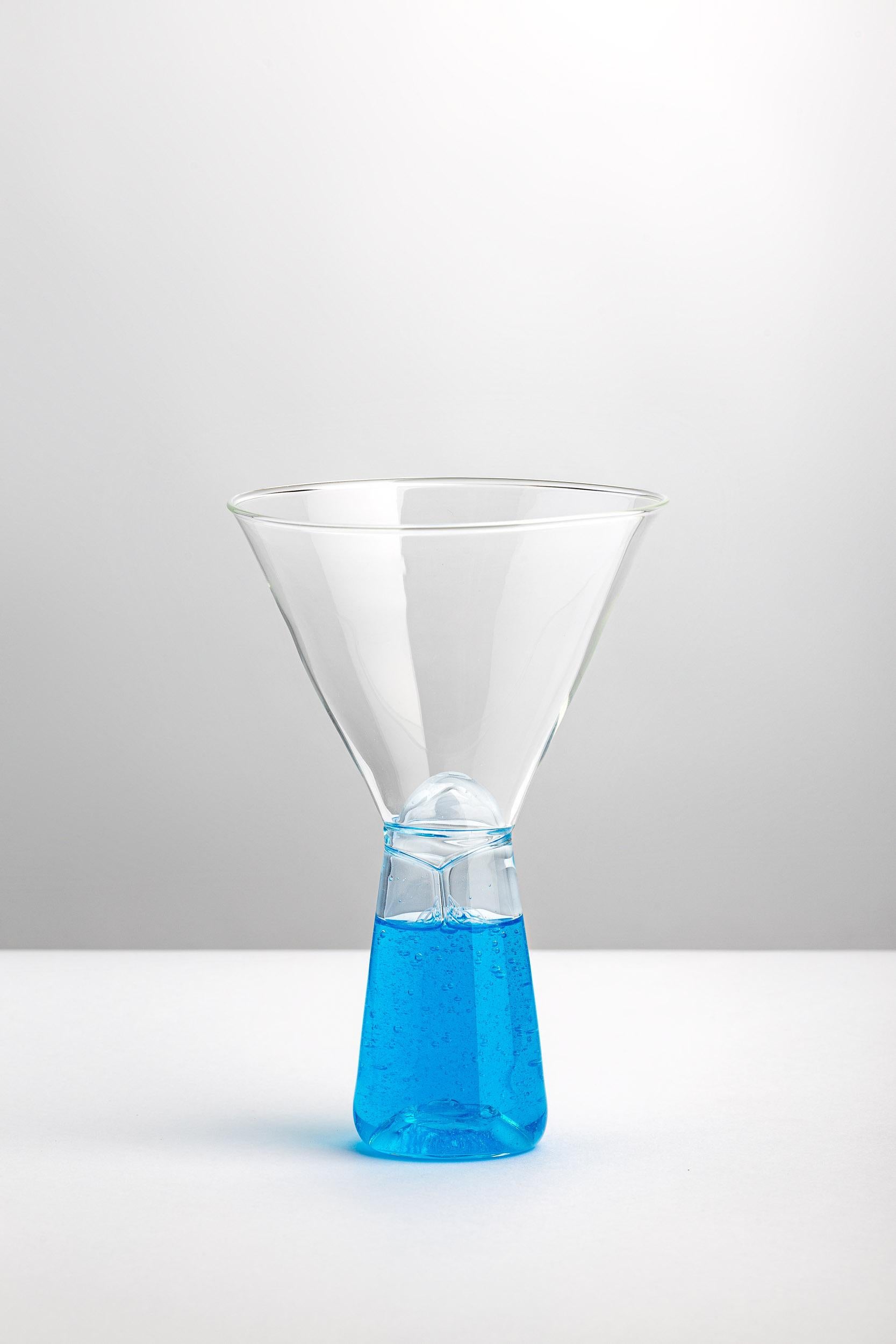 The conical stem filled with colored detergent seems to invade the chalice cup at every sip of our aperitif. Sculpturally beautiful, VELENI’s Martini Glass MG-30lb plays on the dichotomy between attraction and repulsion: every time we have a drink