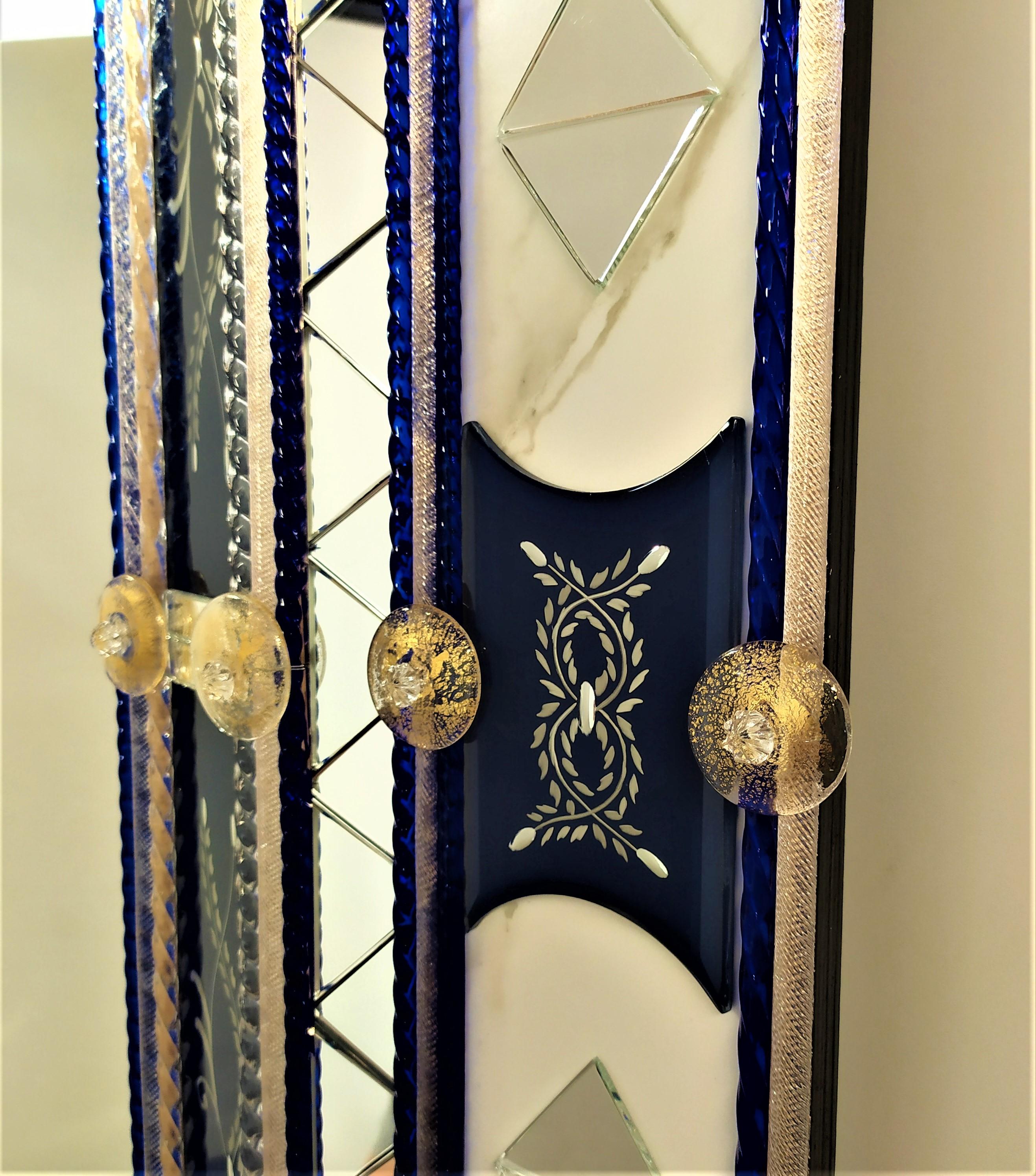 Miroir en verre de Murano, avec bandes et pièces biseautées gravées, argenté avec de l'argent pur de couleur bleue, avec insertion de détails en miroir transparent en forme de triangle, baguettes en verre de Murano en cristal et Madone de couleur